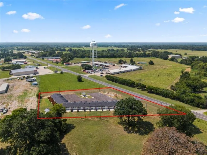 Multi-unit complex with individual patios, surface parking, and a fenced perimeter