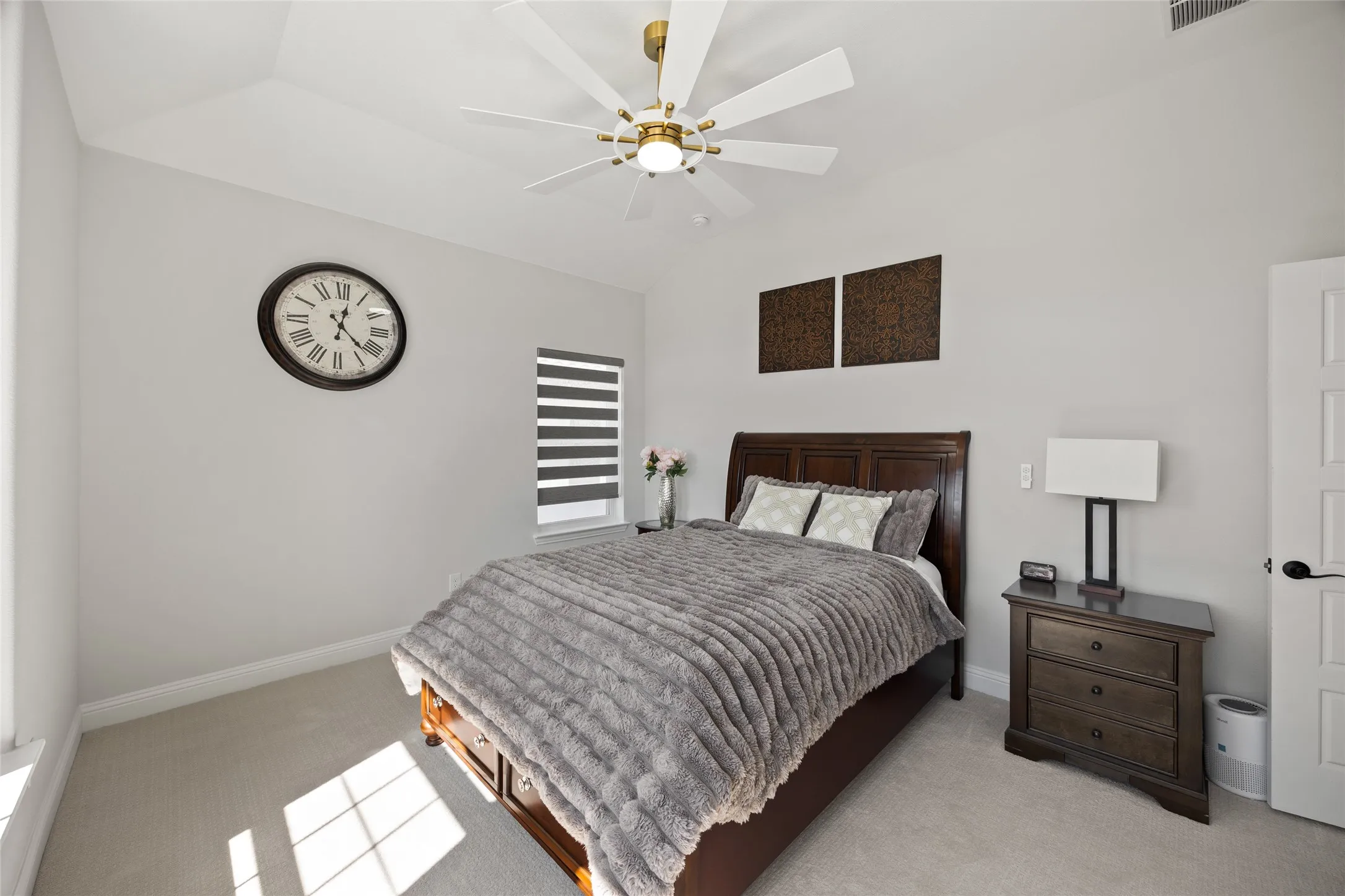 Vaulted ceiling, ceiling fan with integrated lighting, window with horizontal blinds, built-in panel door, and light-colored carpeting