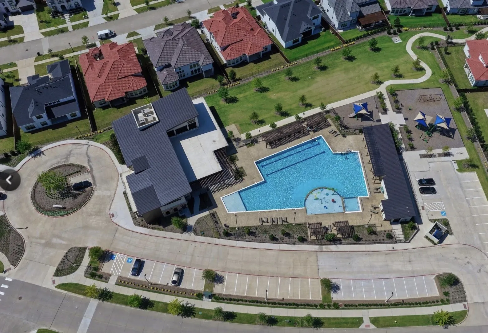 Community pool with integrated wading area, adjacent clubhouse, and ample on-site parking
