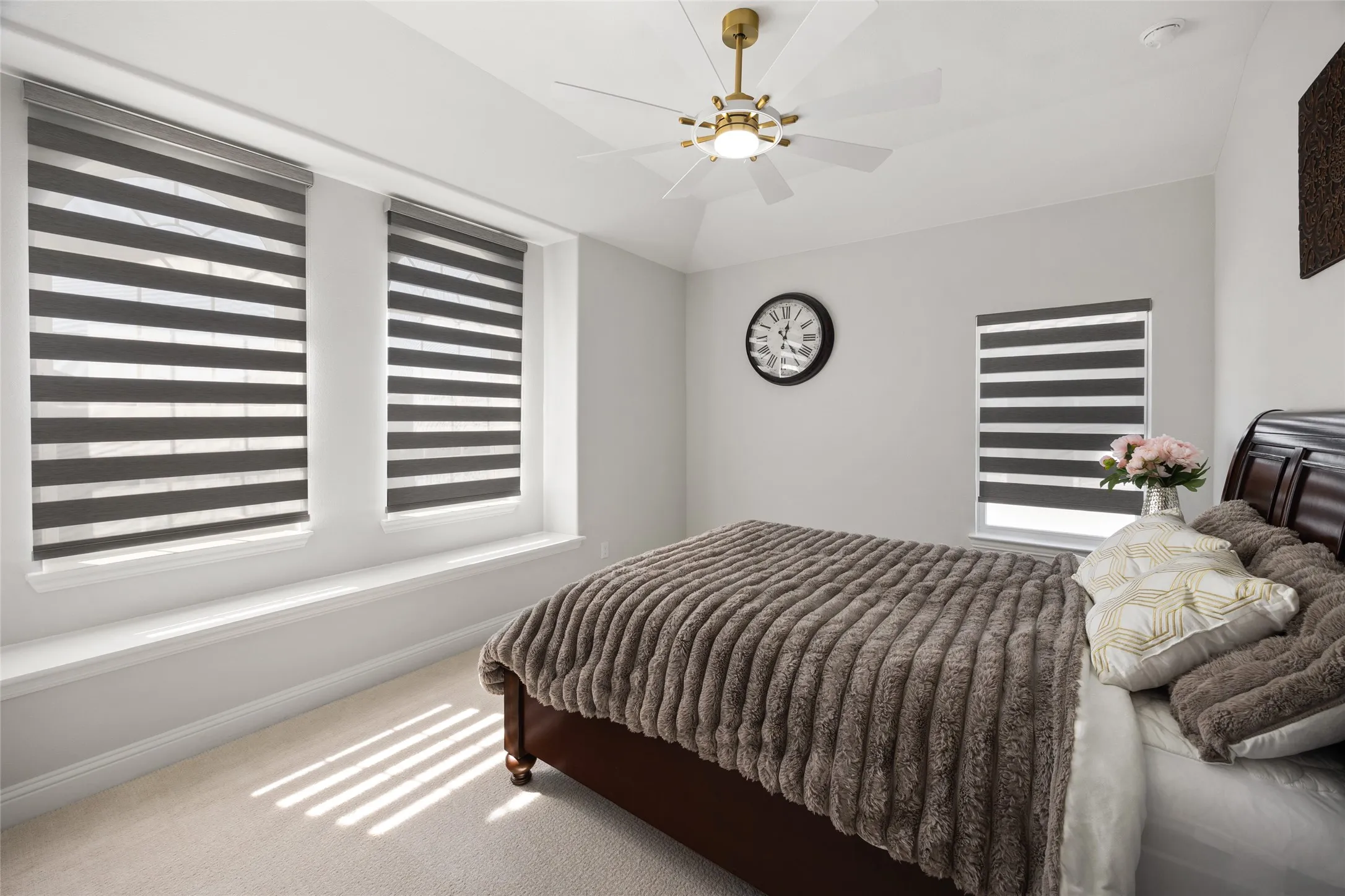 Vaulted ceiling with a gold-finish ceiling fan and integrated lighting