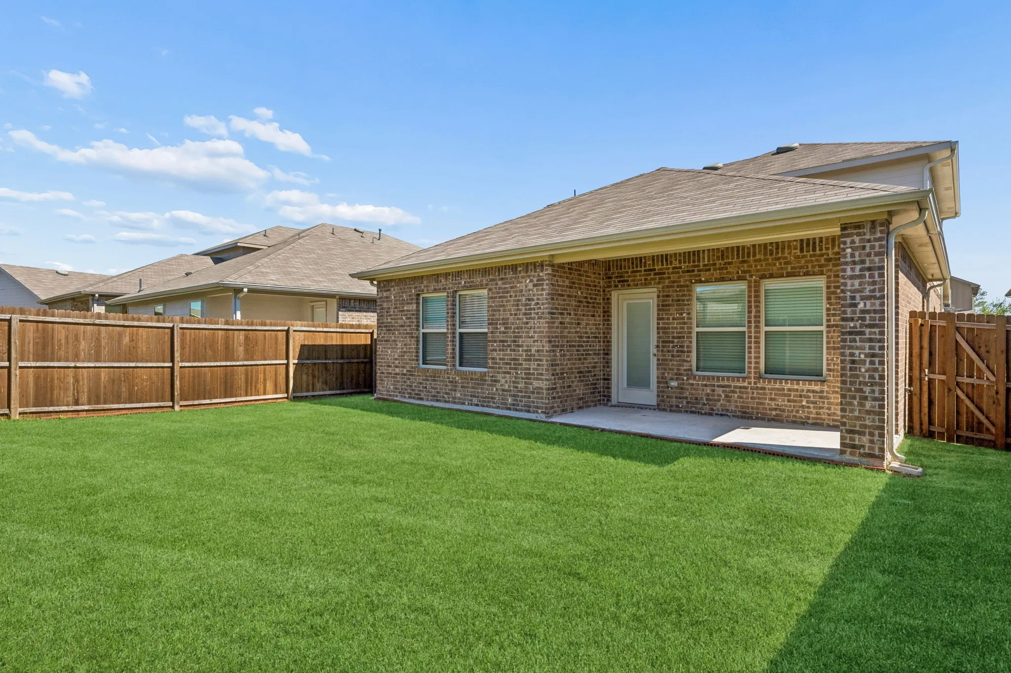 Expansive backyard with a wood privacy fence and a covered patio