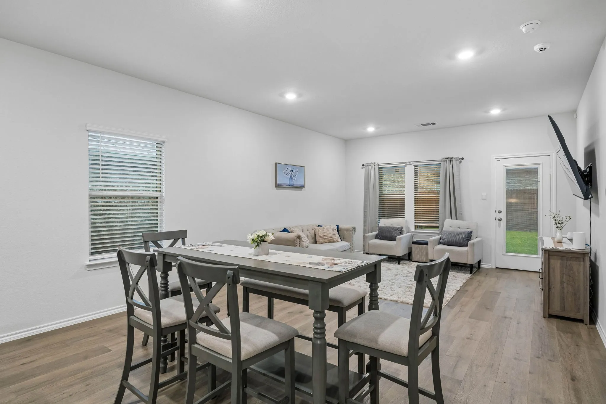 Spacious open-concept living area featuring wood-finish flooring, recessed lighting, and ample natural light from multiple windows