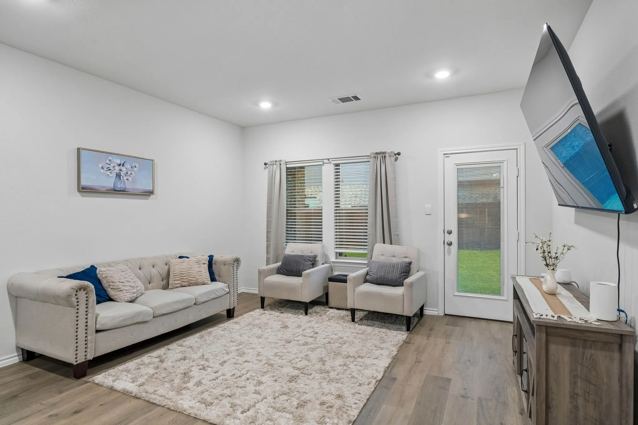 Open-concept living space with recessed lighting and ample natural light from windows to the back yard
