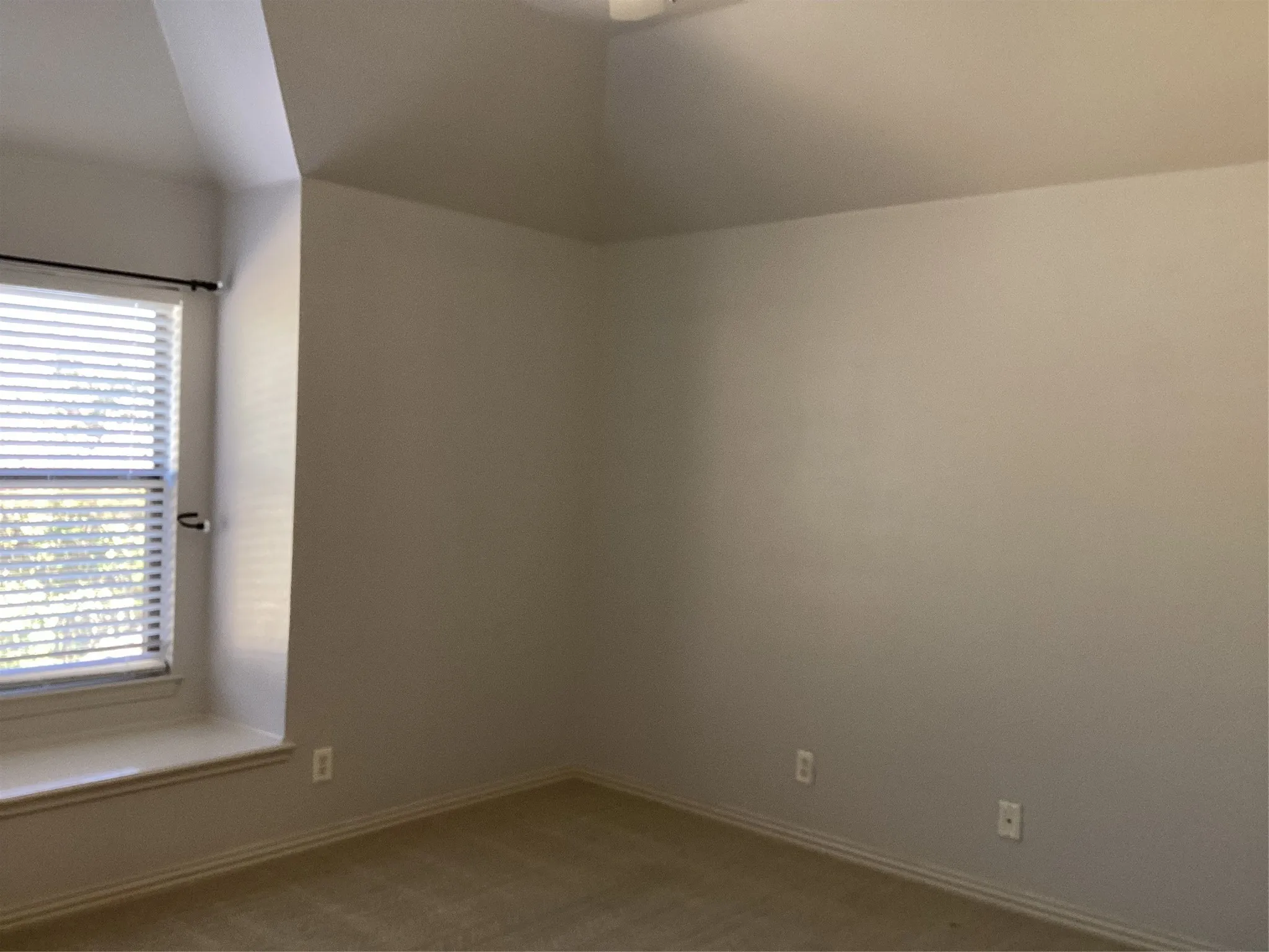 Carpeted flooring, window with blinds, window seat, vaulted ceiling, and light-colored walls