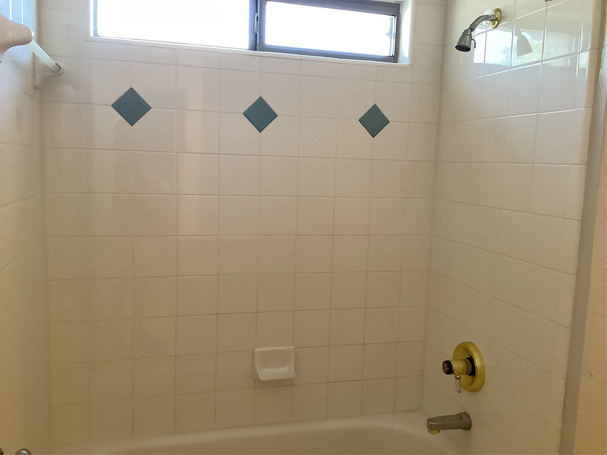 White tiled shower surround with diamond accent tiles