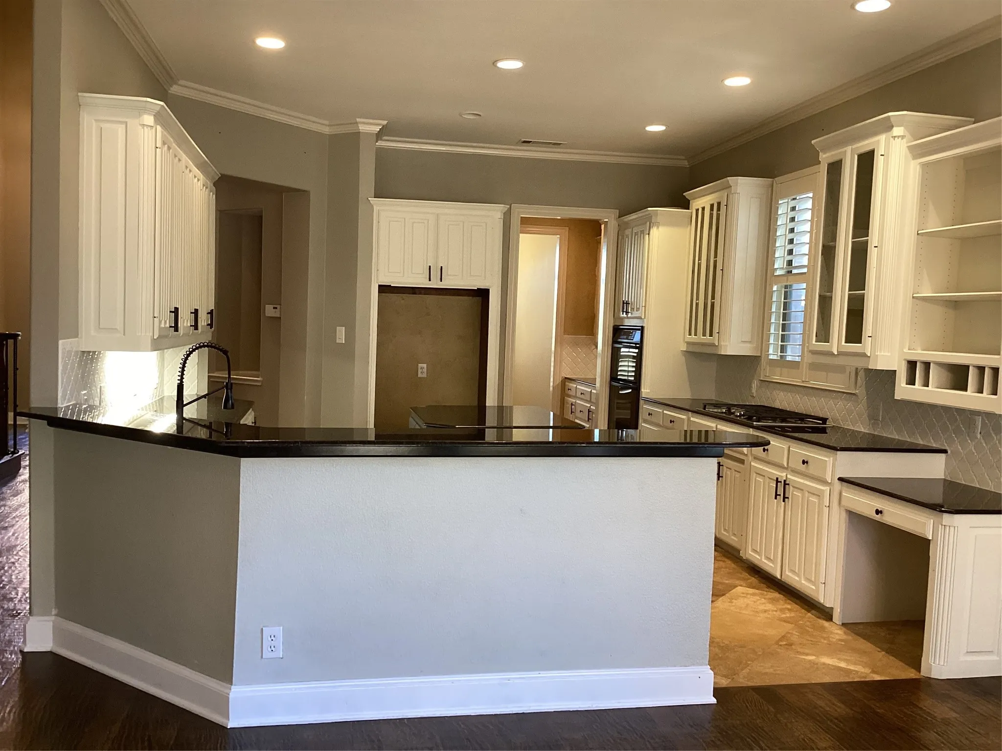 Kitchen featuring white cabinetry, dark countertops, recessed lighting, and a tile backsplash