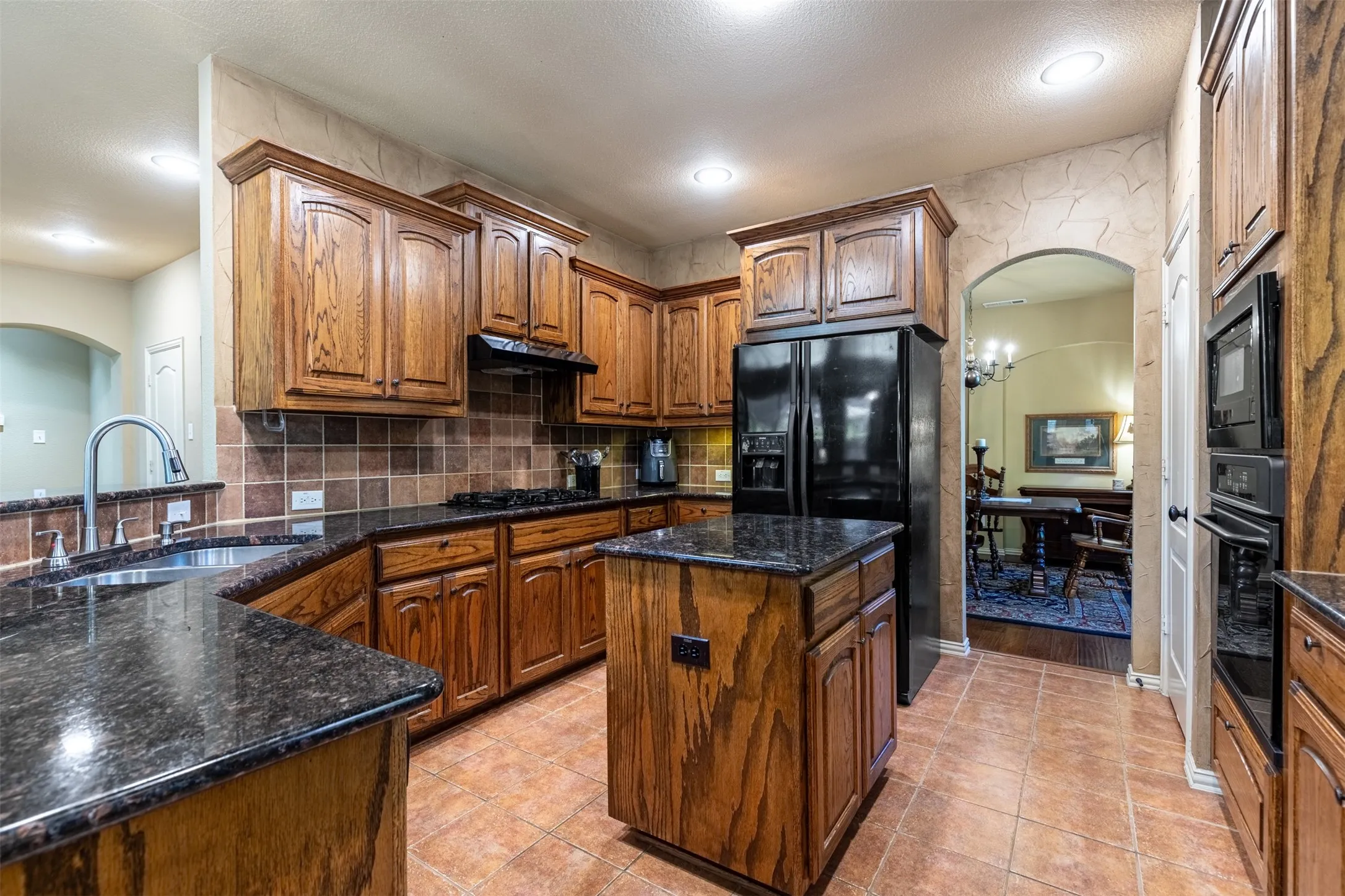 Kitchen boasts warm cabinetry and granite countertops.