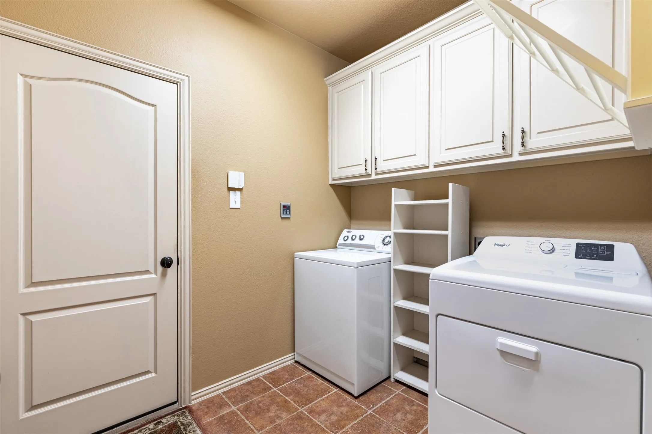 Laundry room features built-in cabinetry.