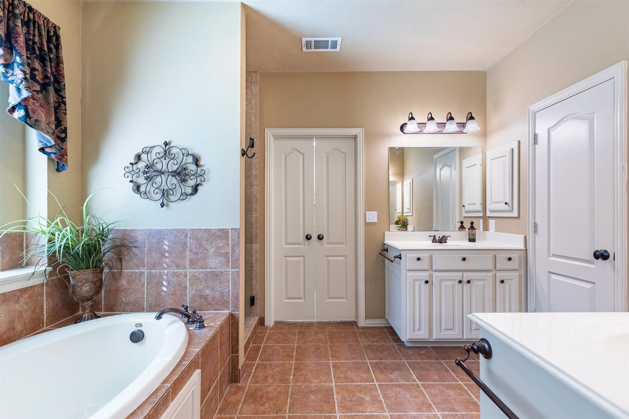 En-suite bath with dual vanities.