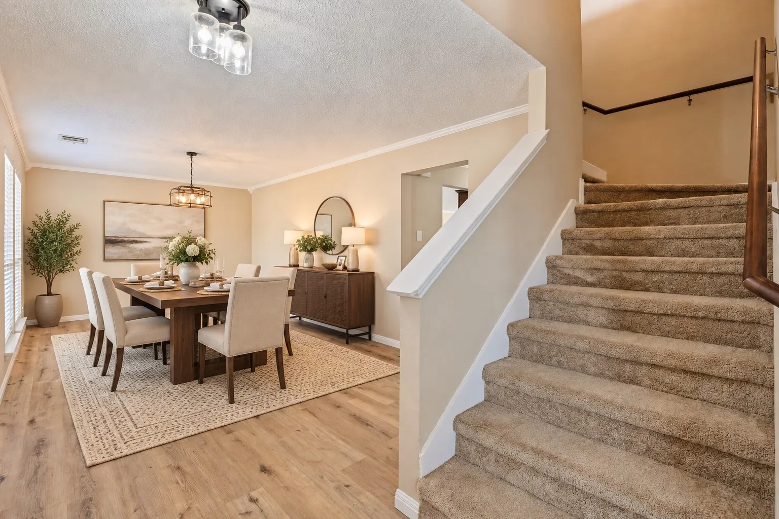 Wood-finish flooring throughout the dining area, featuring a decorative chandelier and window blinds