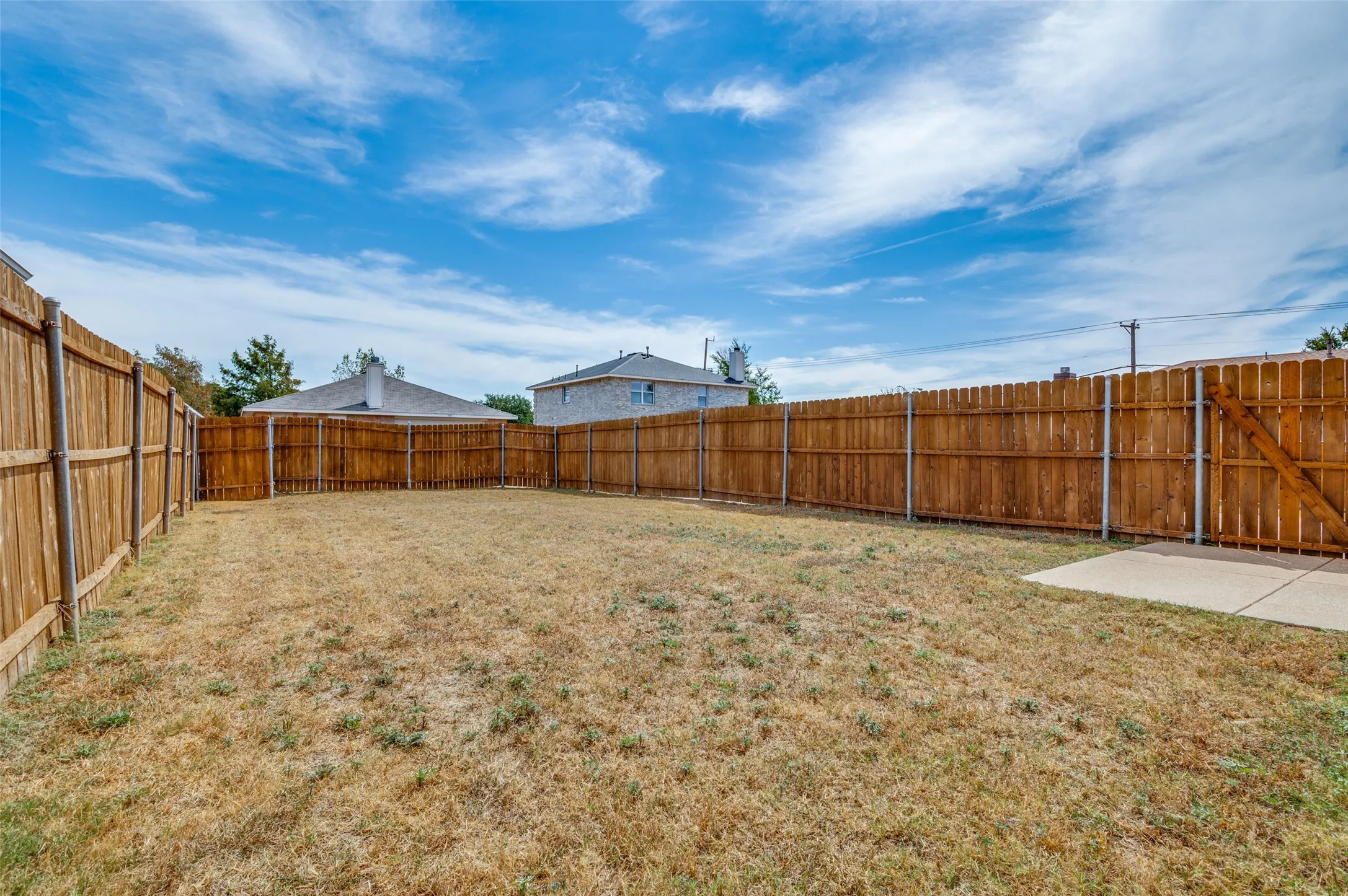 Fenced backyard with a concrete patio