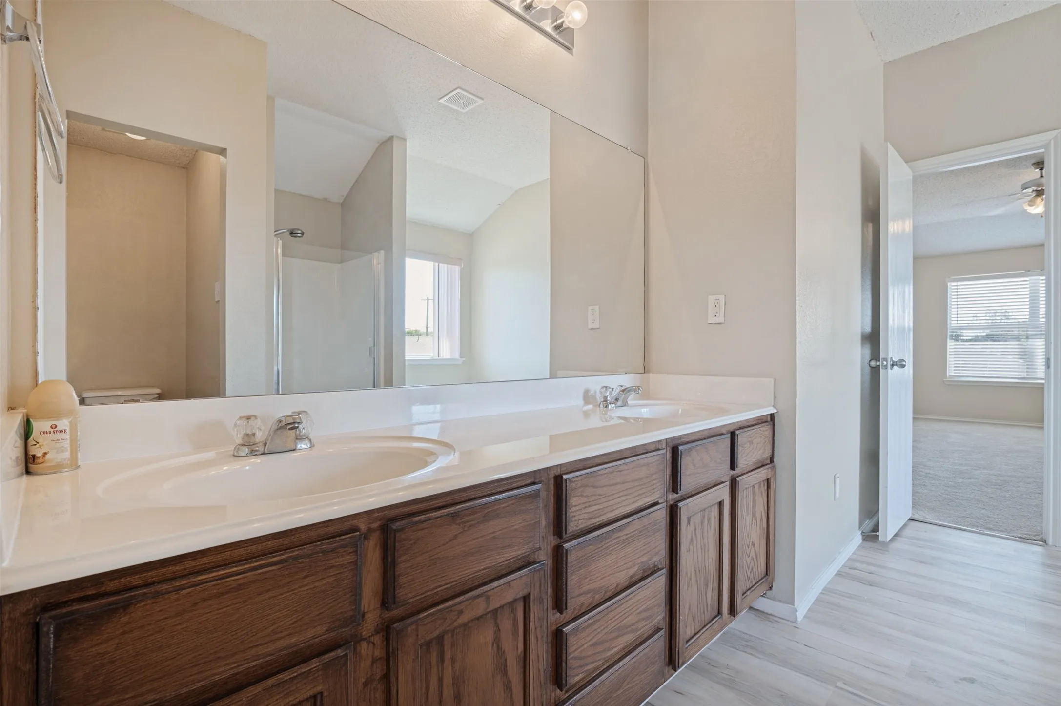 Dual vanity with wood-finish cabinetry and integrated sinks