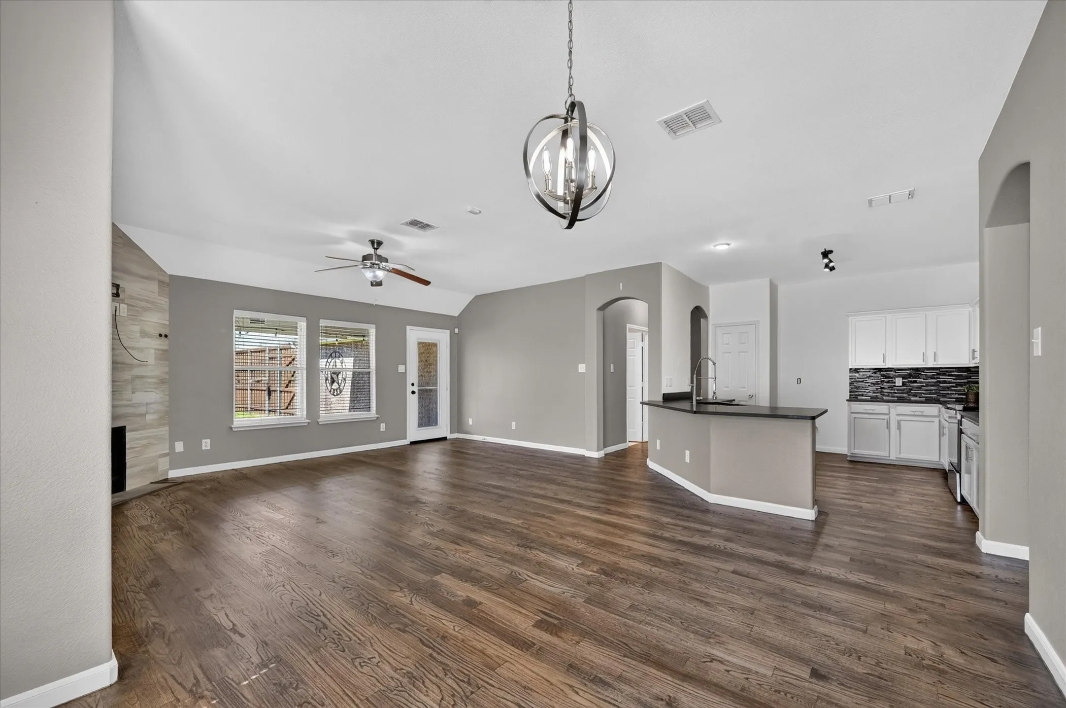 Wood-finish flooring throughout, vaulted ceilings, and a decorative pendant light fixture