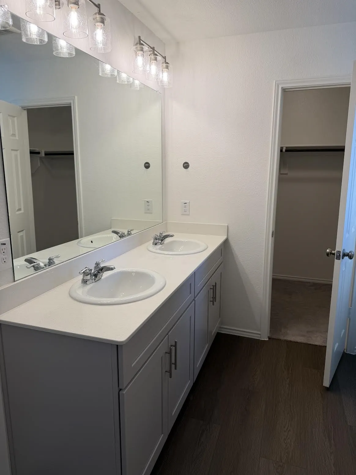 Dual vanity with white undermount sinks, light-toned countertop, and grey cabinetry