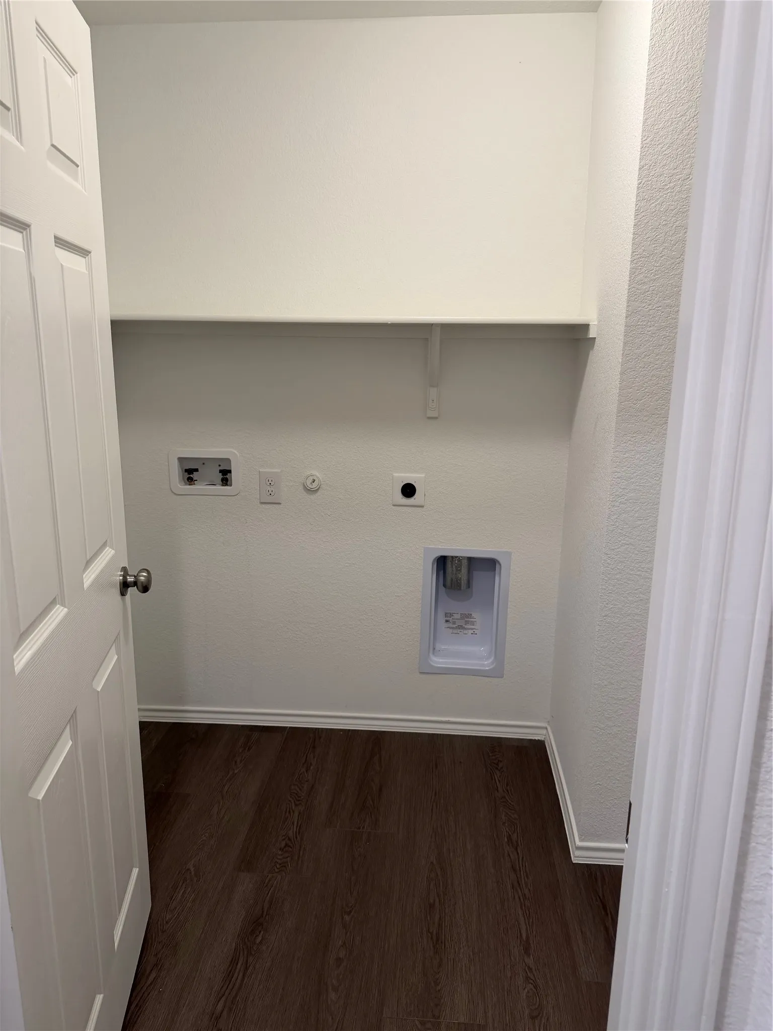 Utility area with wood-finish flooring, white walls, and an integrated shelf