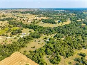 Expansive rural landscape with multiple residential structures, wooded areas, and open fields