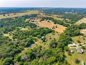 Expansive rural landscape featuring scattered homes, mature trees, and open fields