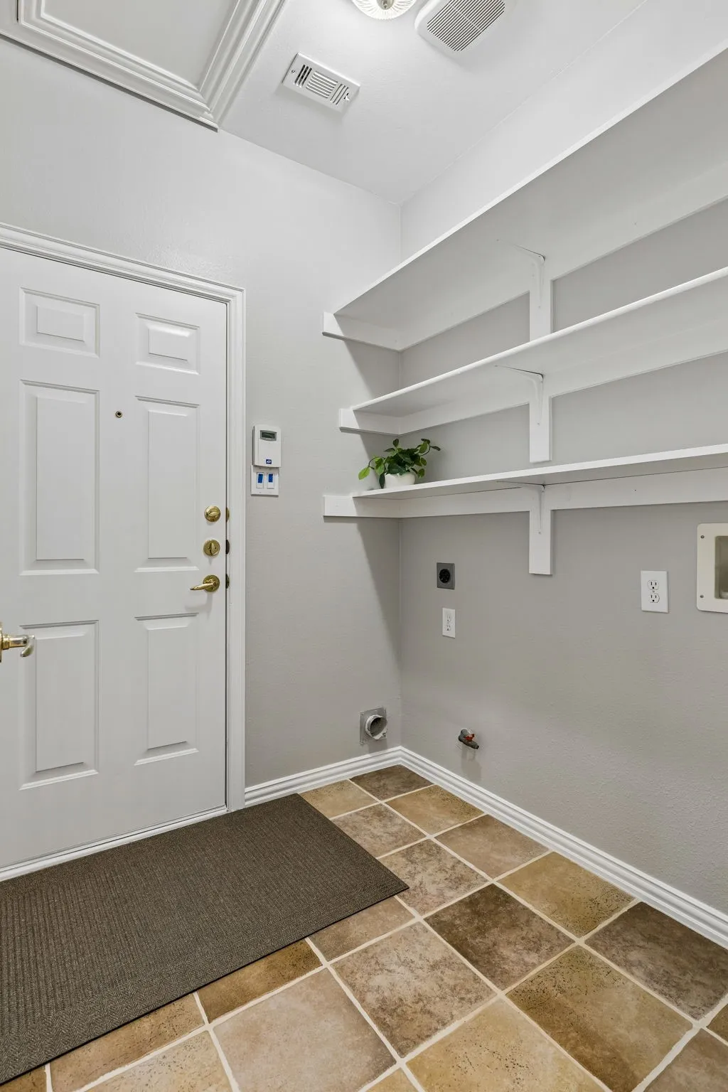 Utility room has gas and electrical hookups along with built in shelves