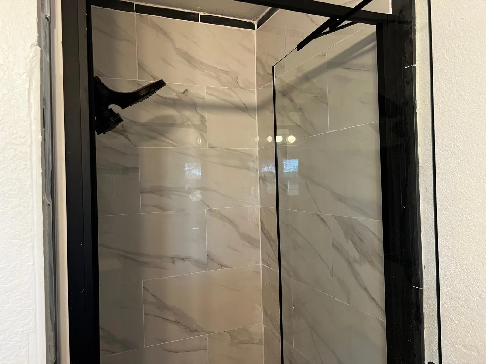 Shower enclosure with a matte black frame and clear glass door