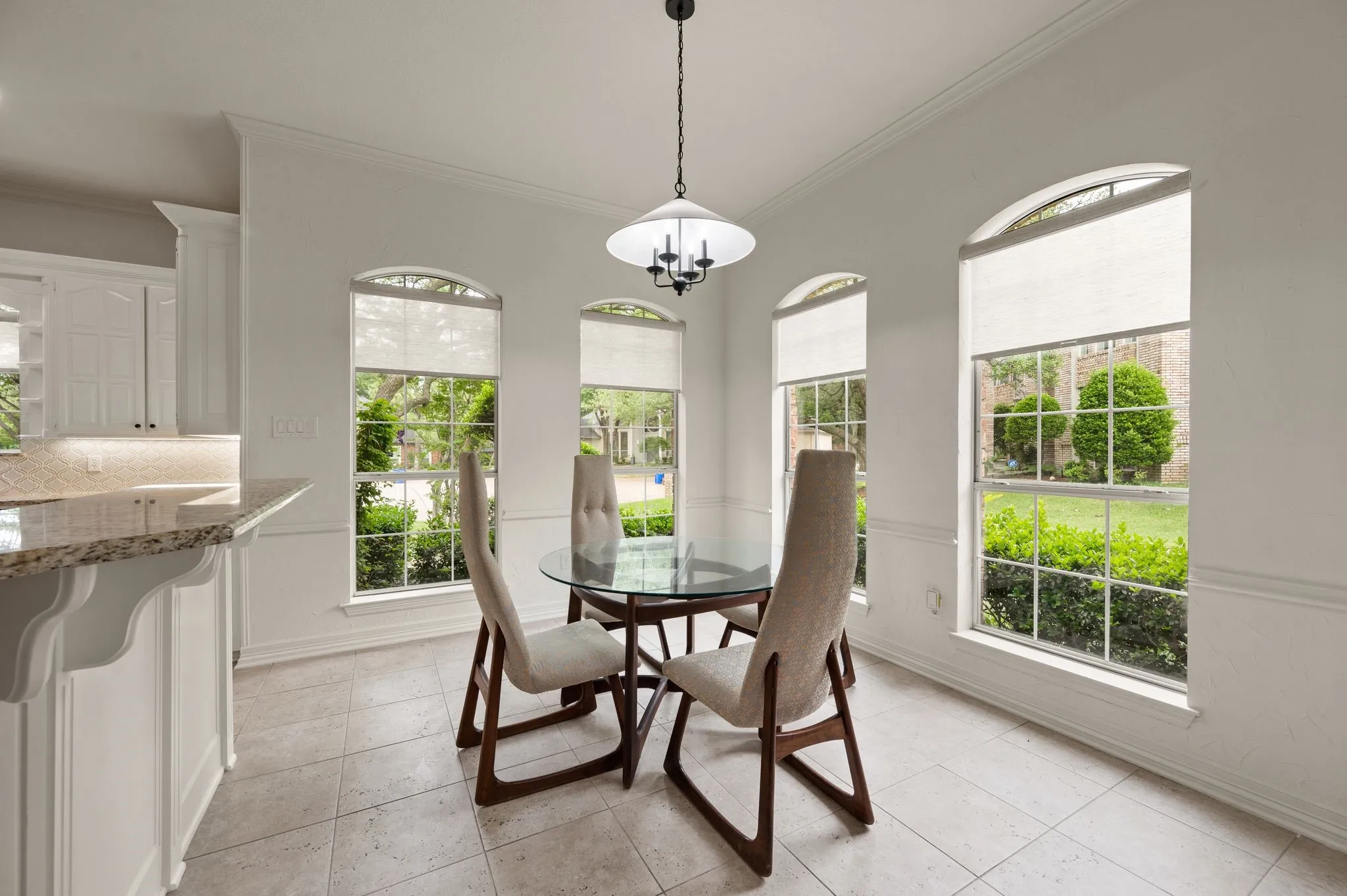 Dining area with a healthy amount of sunlight, baseboards, ornamental molding, and light tile patterned flooring