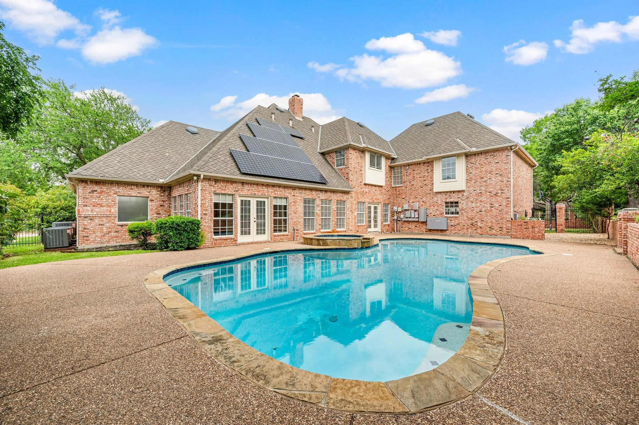 View of pool featuring fence, french doors, a fenced in pool, a patio area, and an in ground hot tub