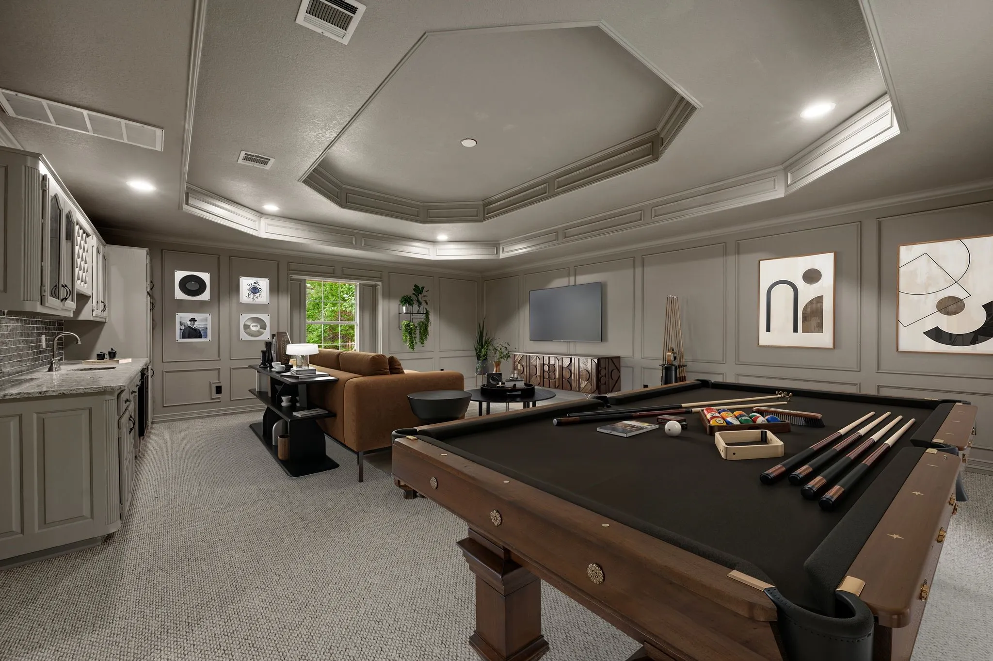 Rec room with visible vents, ornamental molding, a raised ceiling, and a decorative wall
