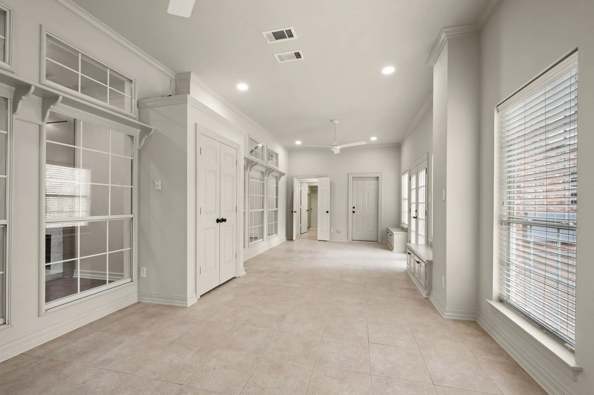Hallway featuring ornamental molding, recessed lighting, light tile patterned flooring, and visible vents