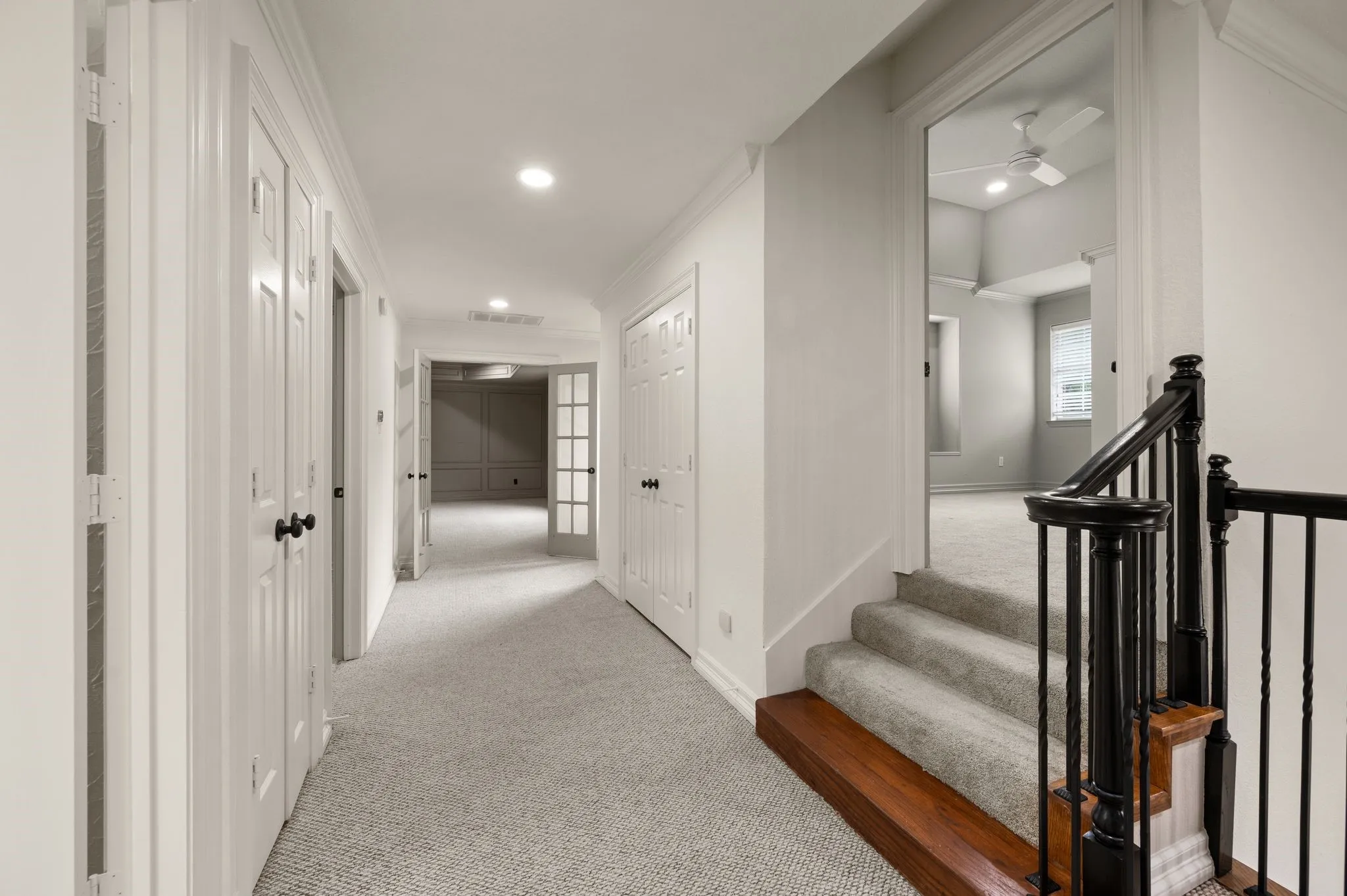 Hallway featuring visible vents, baseboards, ornamental molding, light carpet, and recessed lighting