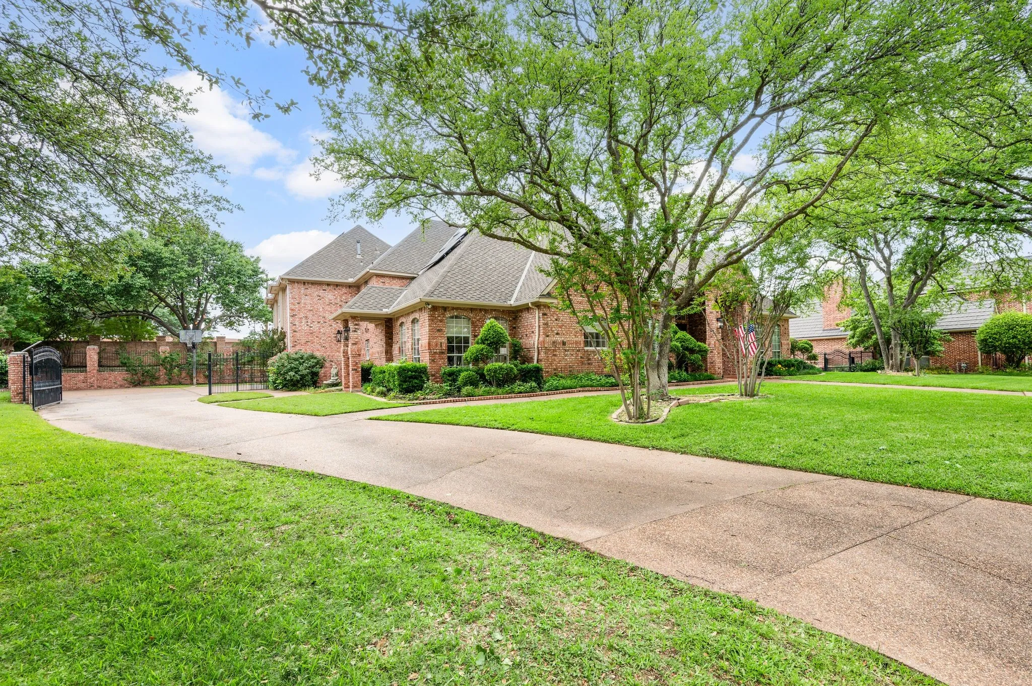 Traditional-style house featuring brick siding, a front lawn, and fence