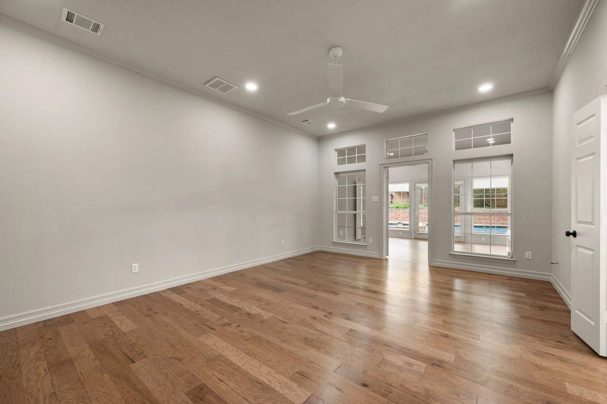 Unfurnished room featuring a ceiling fan, visible vents, light wood finished floors, ornamental molding, and recessed lighting