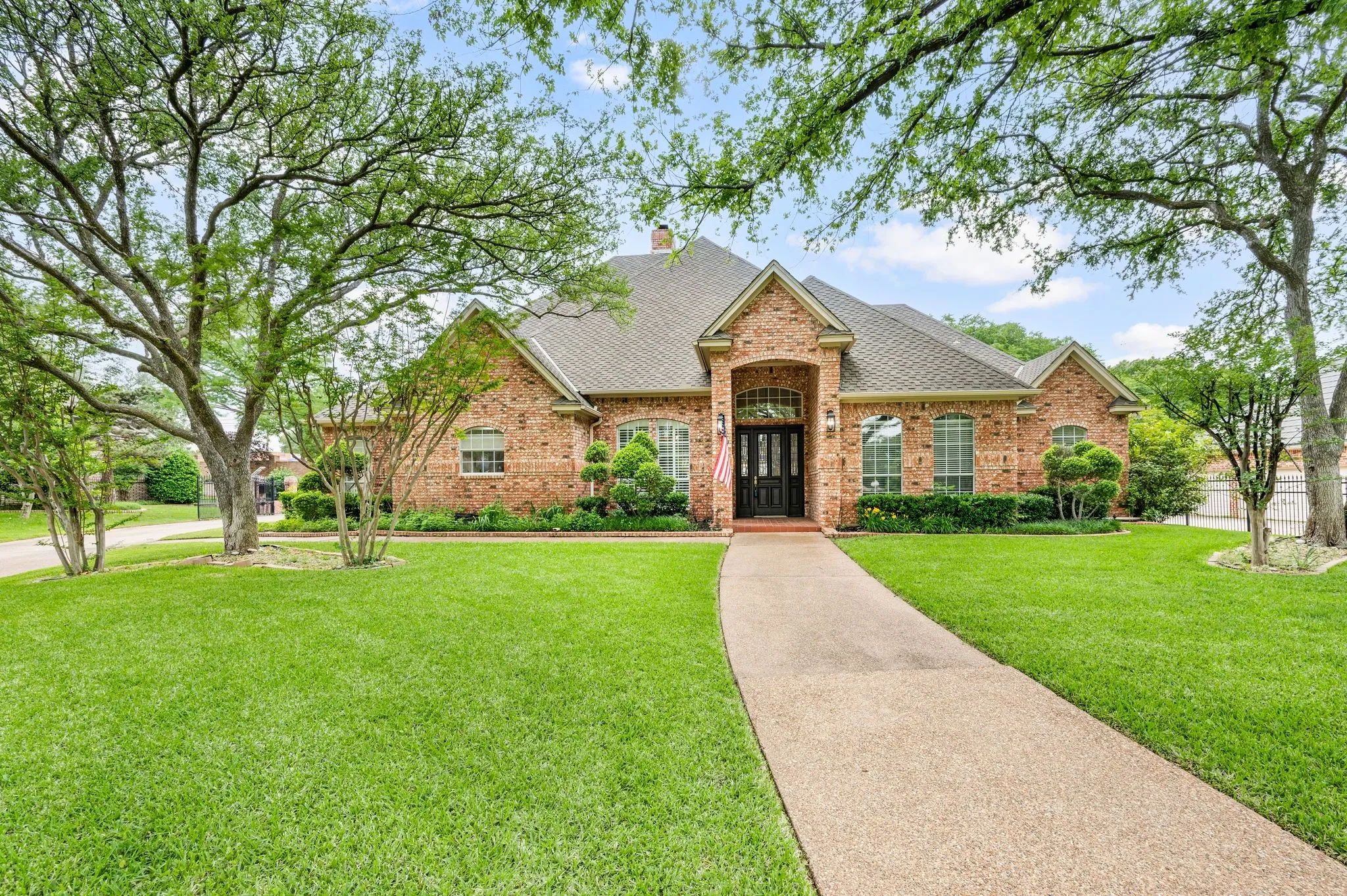 Single story home with a chimney, a shingled roof, a front yard, and brick siding