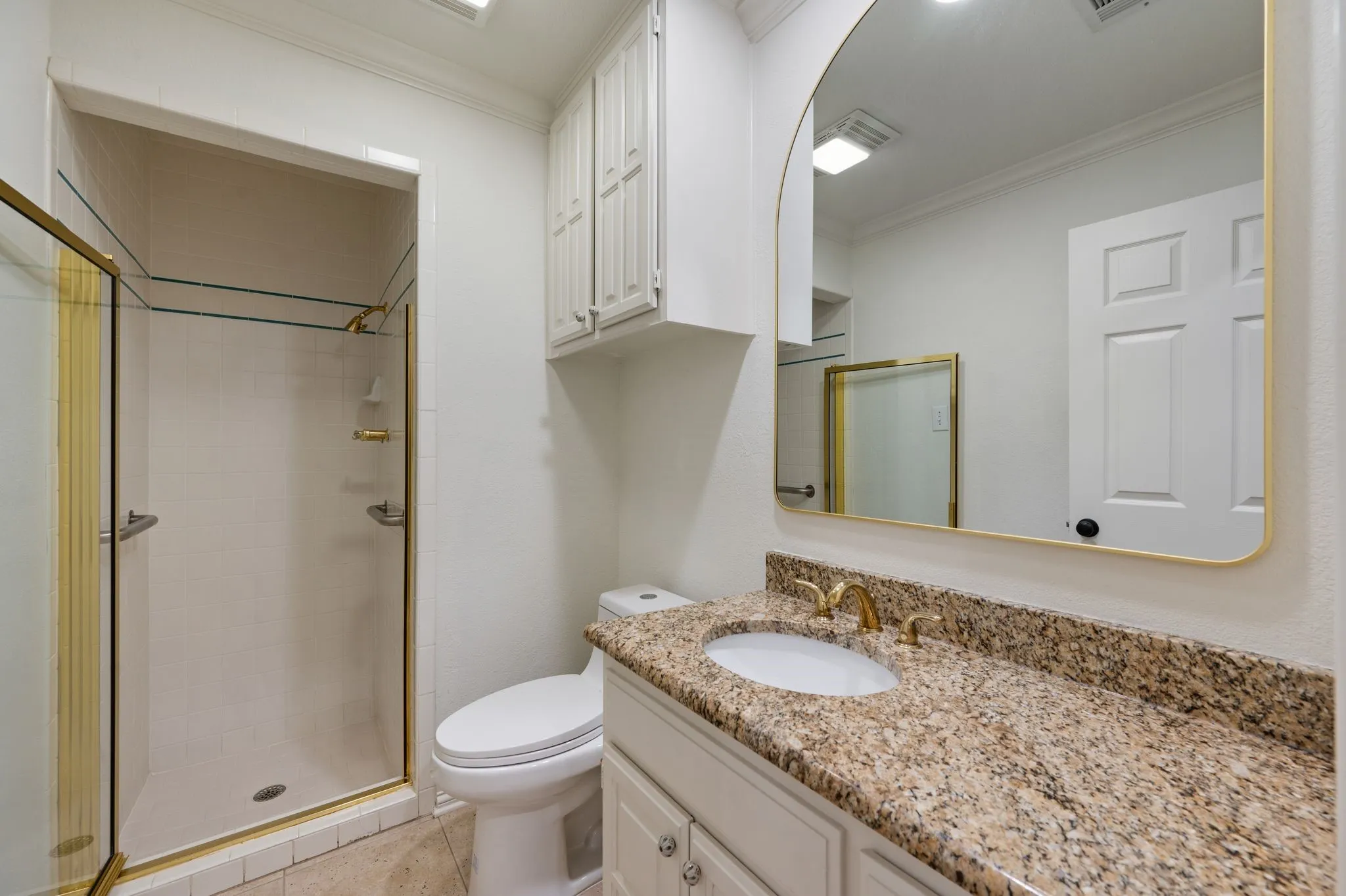 Bathroom featuring toilet, ornamental molding, a shower stall, and vanity