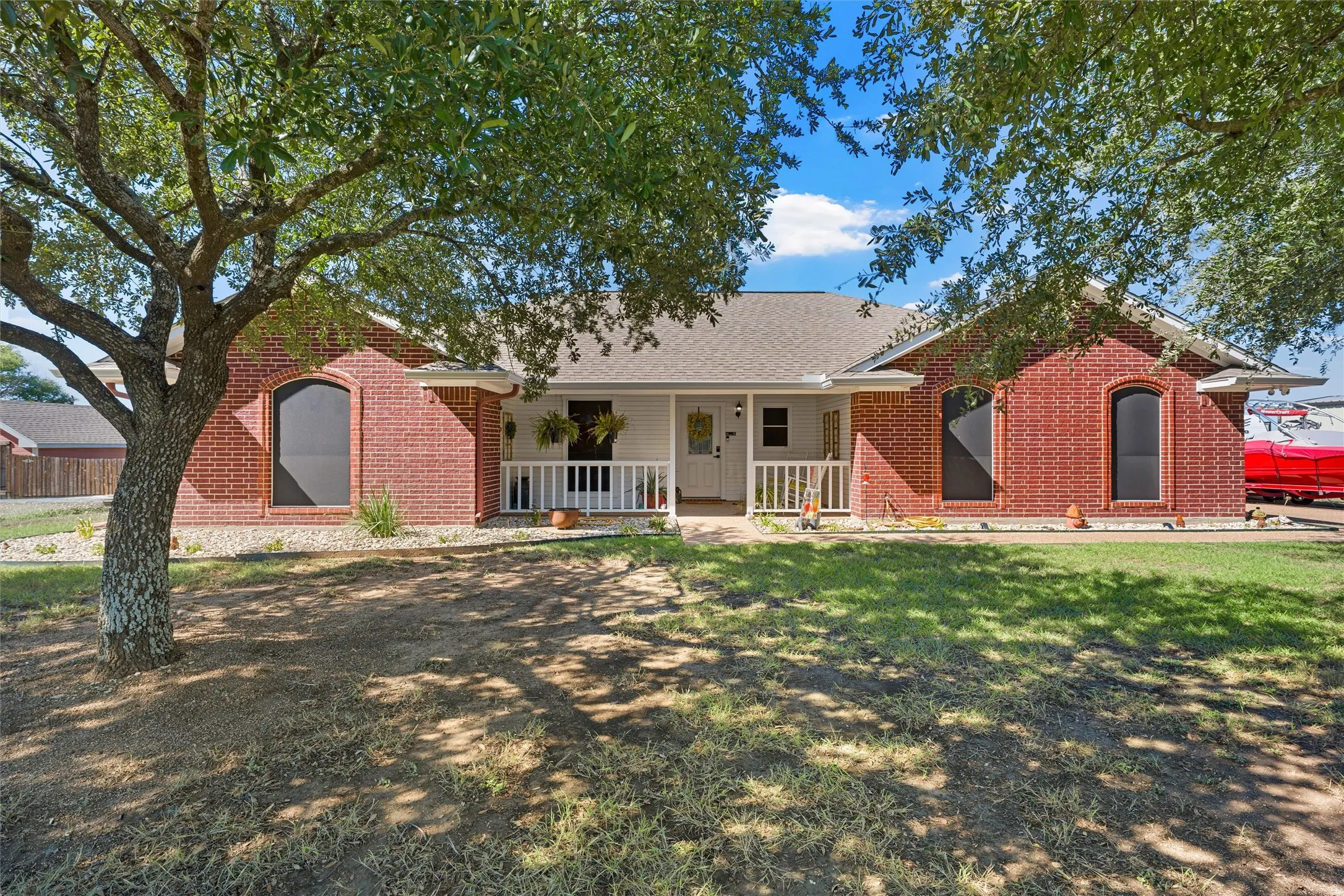 Brick exterior with arched windows, covered front porch, and a gabled roof