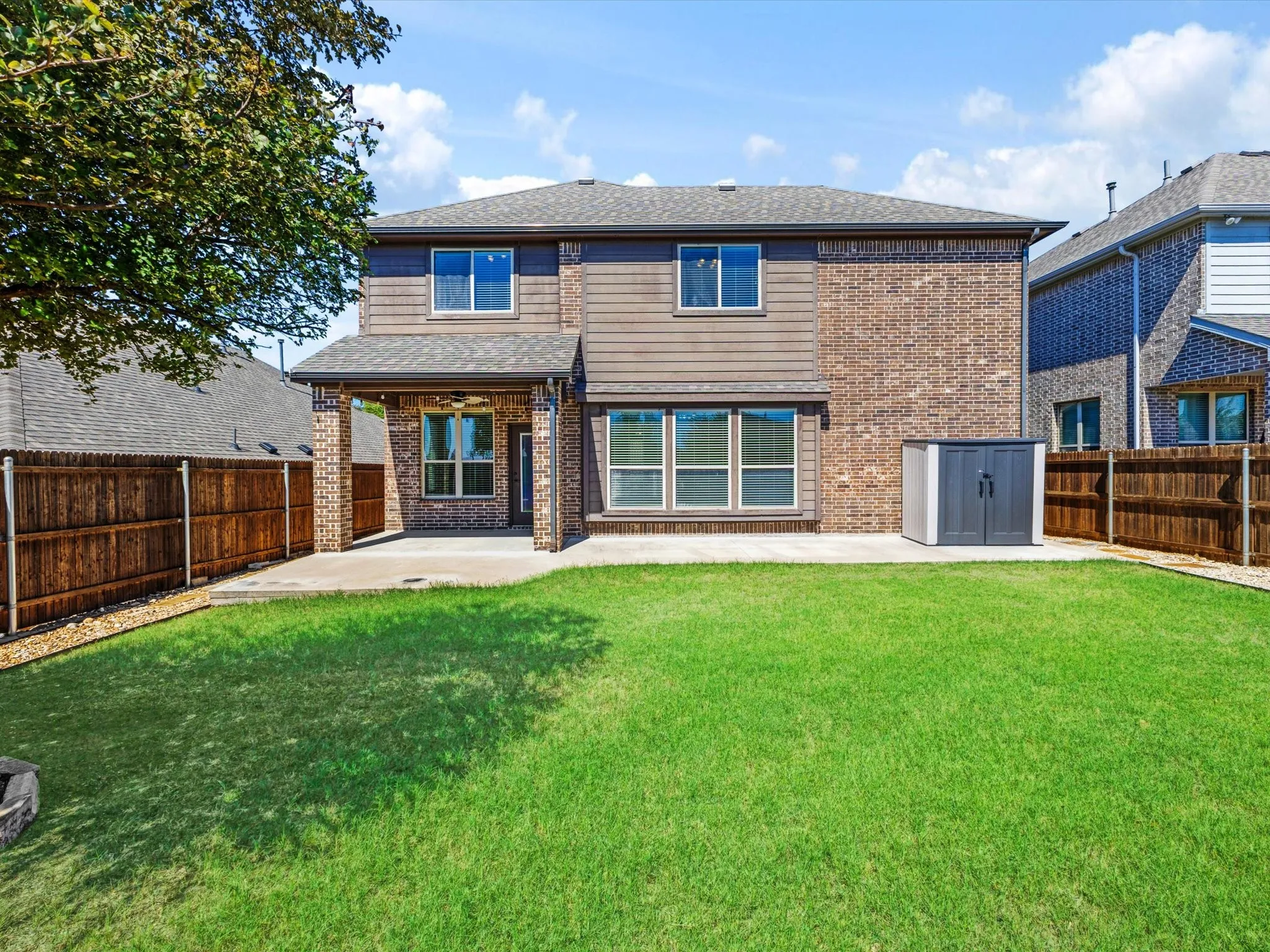 Expansive backyard with a covered patio, concrete slab, and privacy fencing
