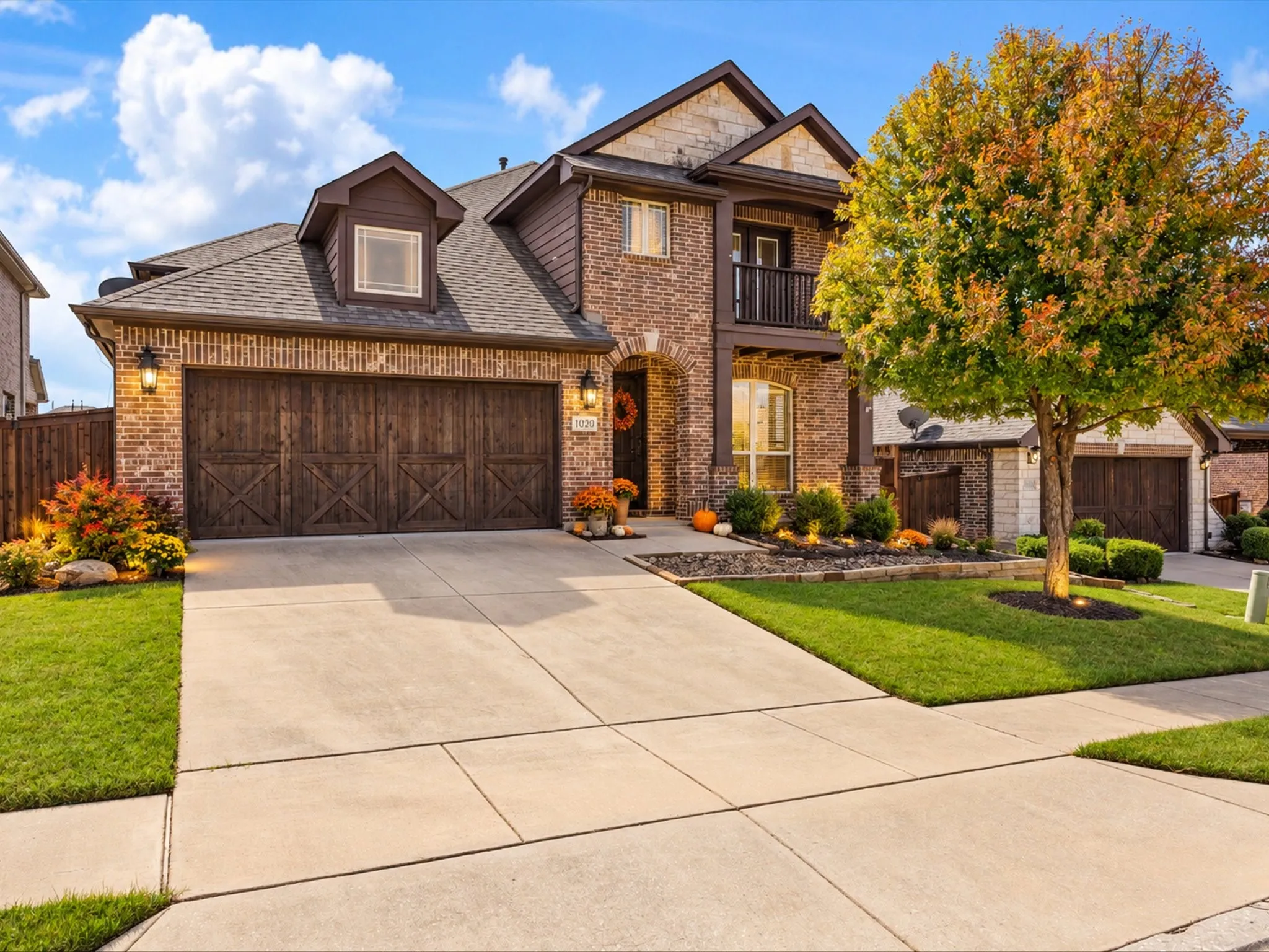 Brick and stone exterior with dark wood-finish garage doors and trim