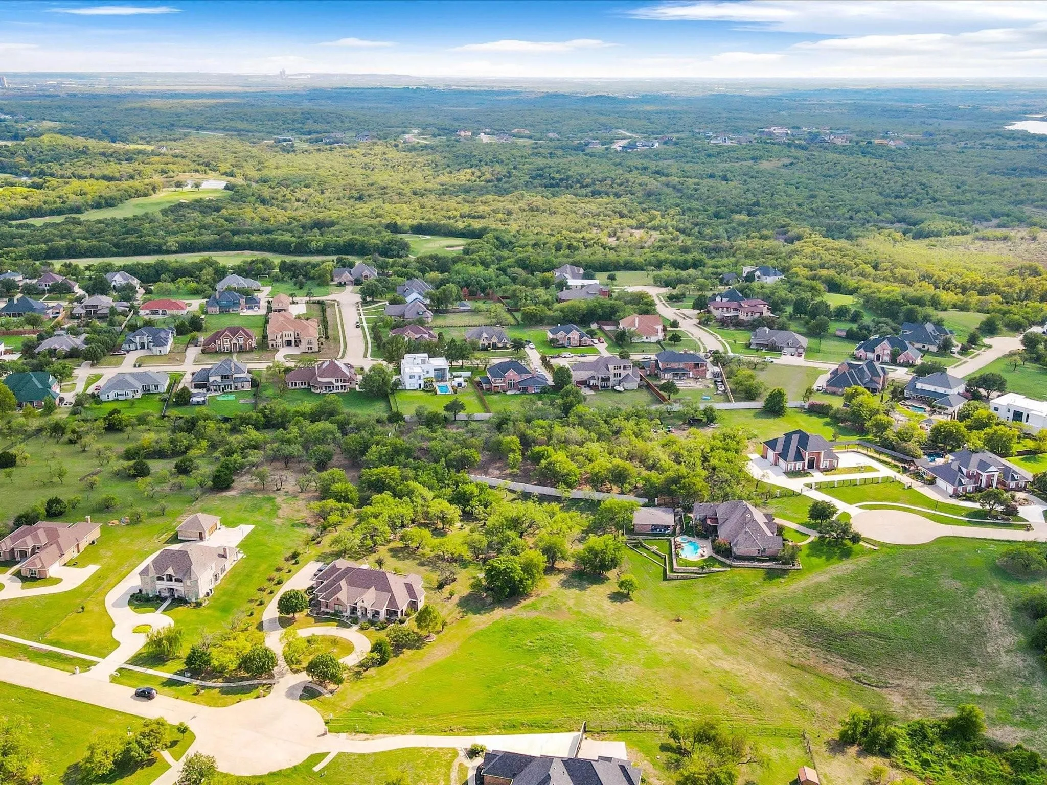 Expansive residential area featuring numerous single-family homes, mature trees, and lush green spaces
