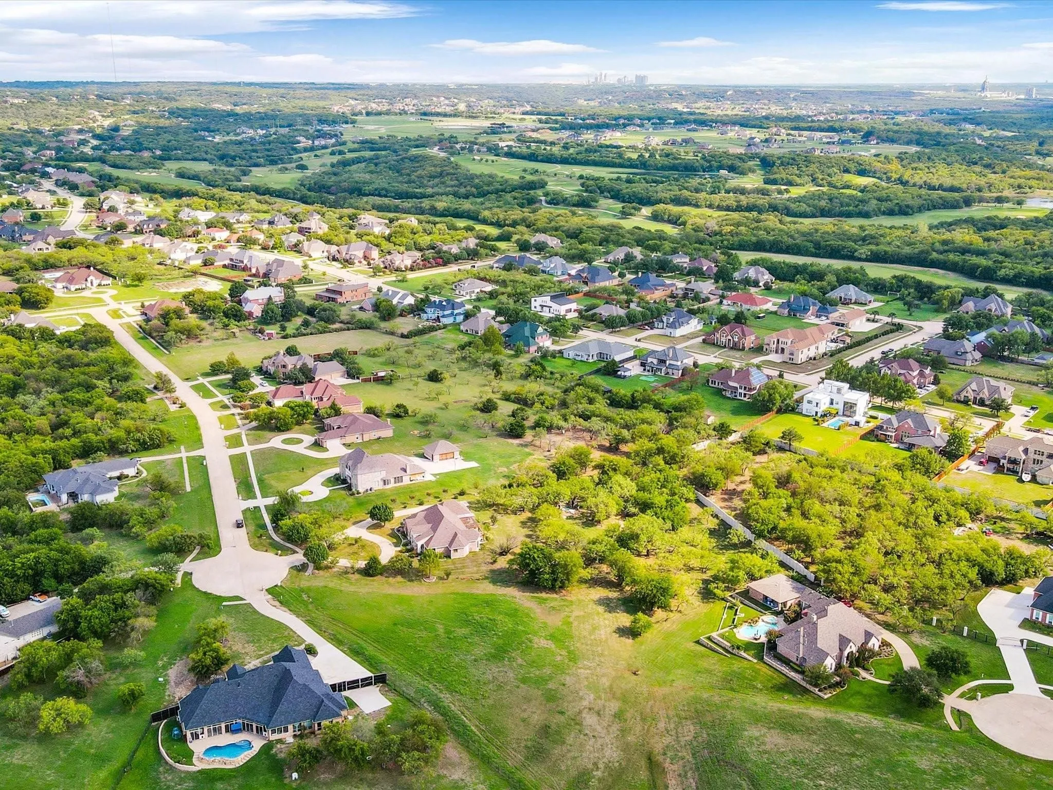 Residential community featuring tree-lined streets, varied architectural styles, and private swimming pools