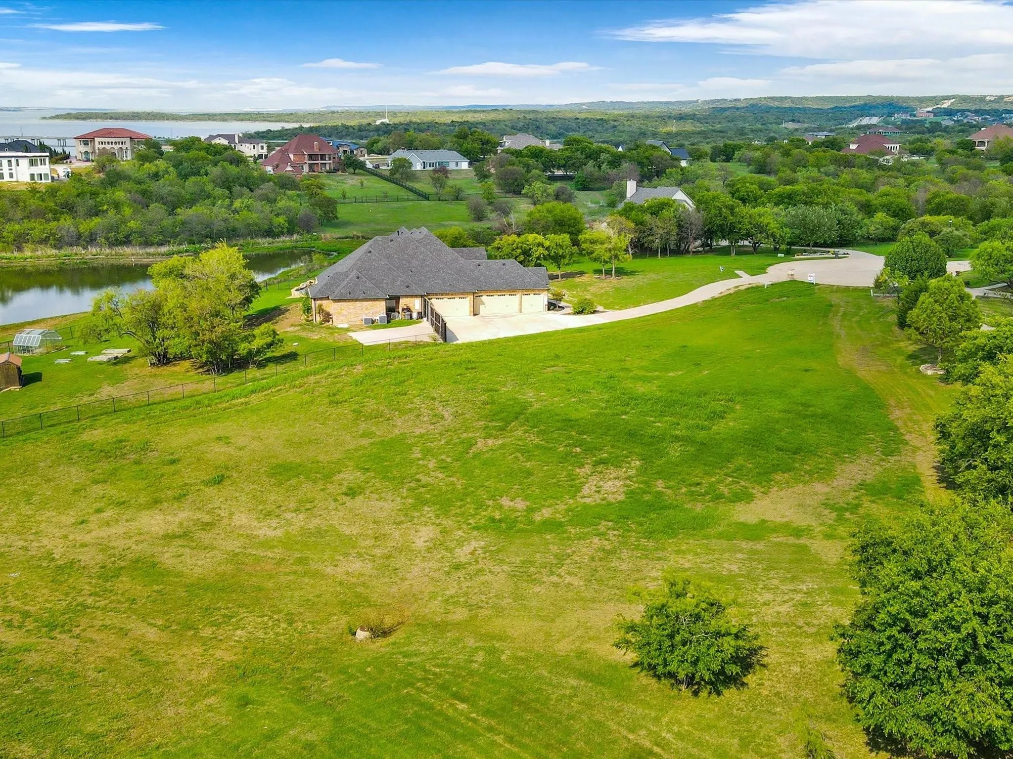 Expansive green landscape with a large residential structure featuring a multi-car garage