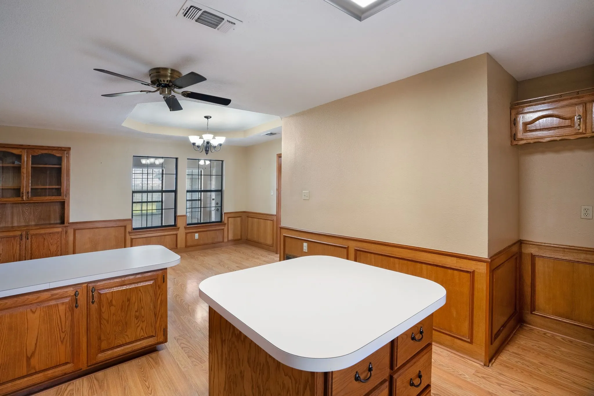 Kitchen with a center island, pendant lighting, ceiling fan, and light hardwood / wood-style floors