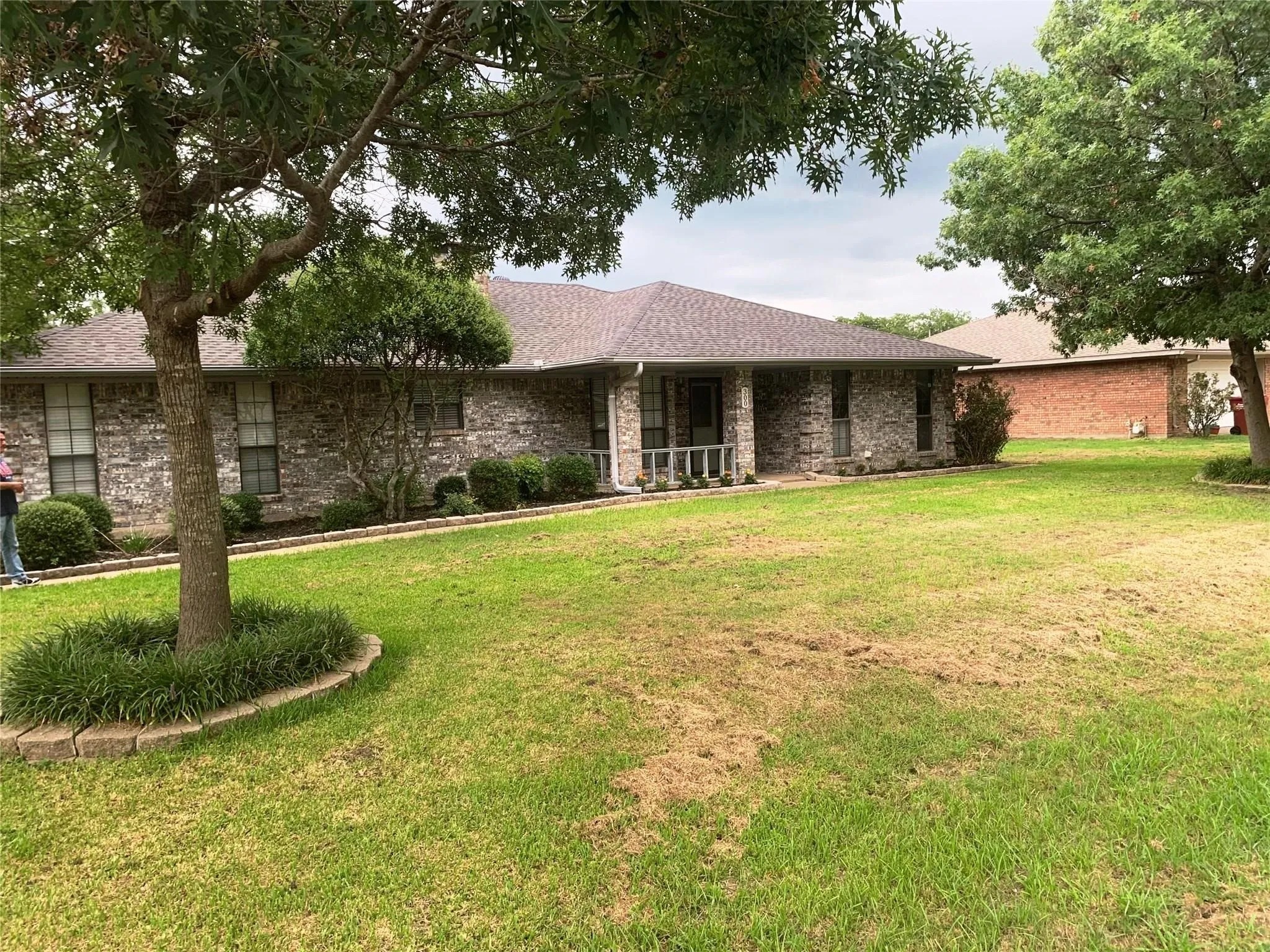 Brick exterior with a covered porch featuring white railings