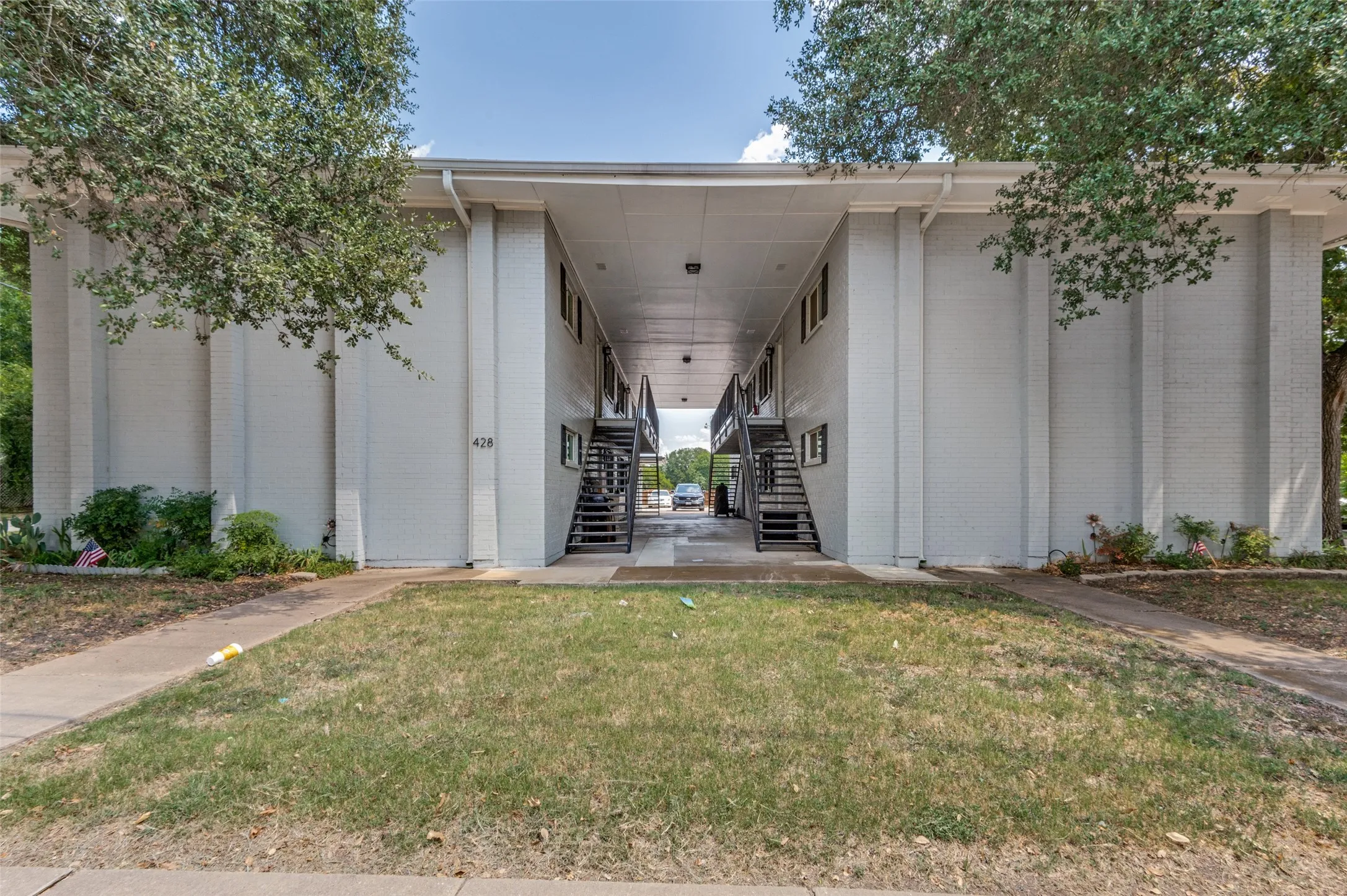 White brick exterior with covered walkways and exterior staircases