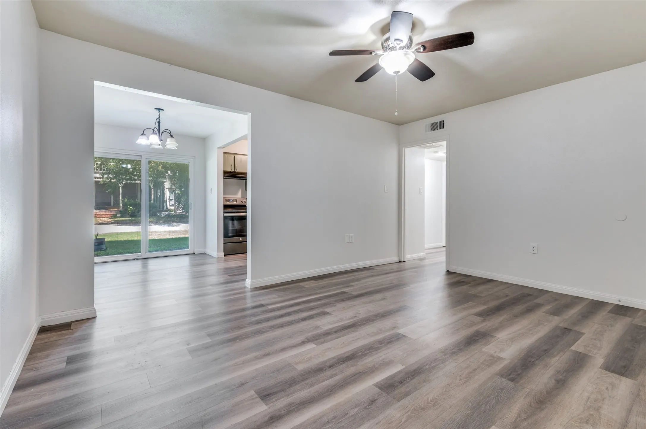 Wood-finish flooring throughout, ceiling fan with integrated lighting, and white wall finishes