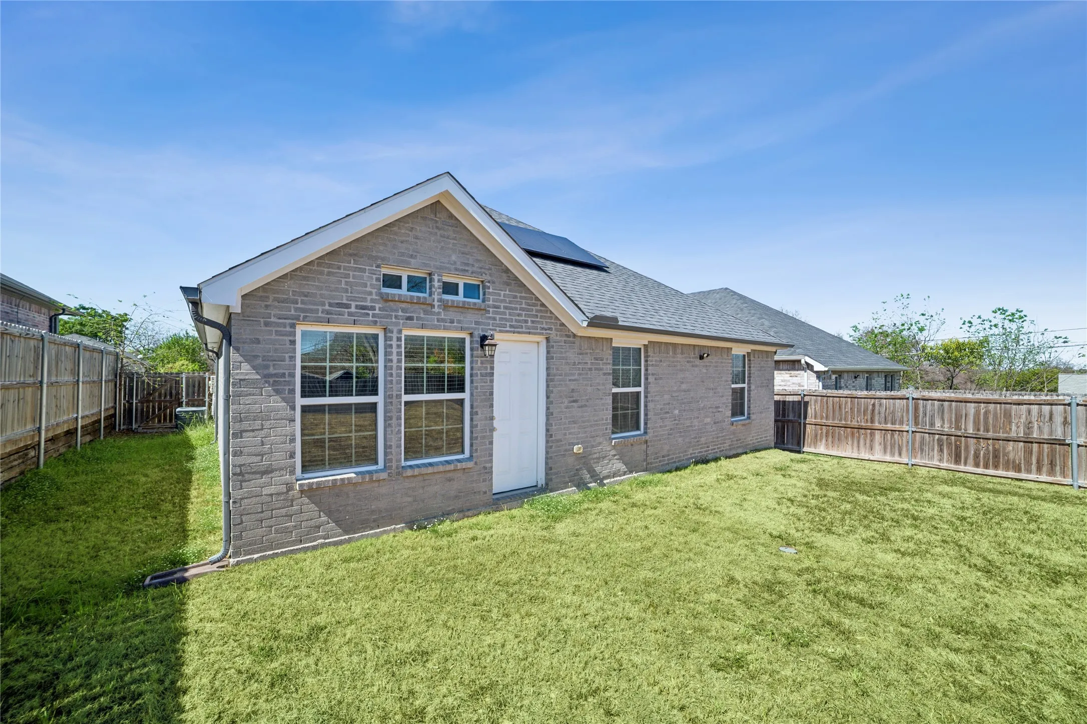 Brick exterior with a gabled roof and solar panels