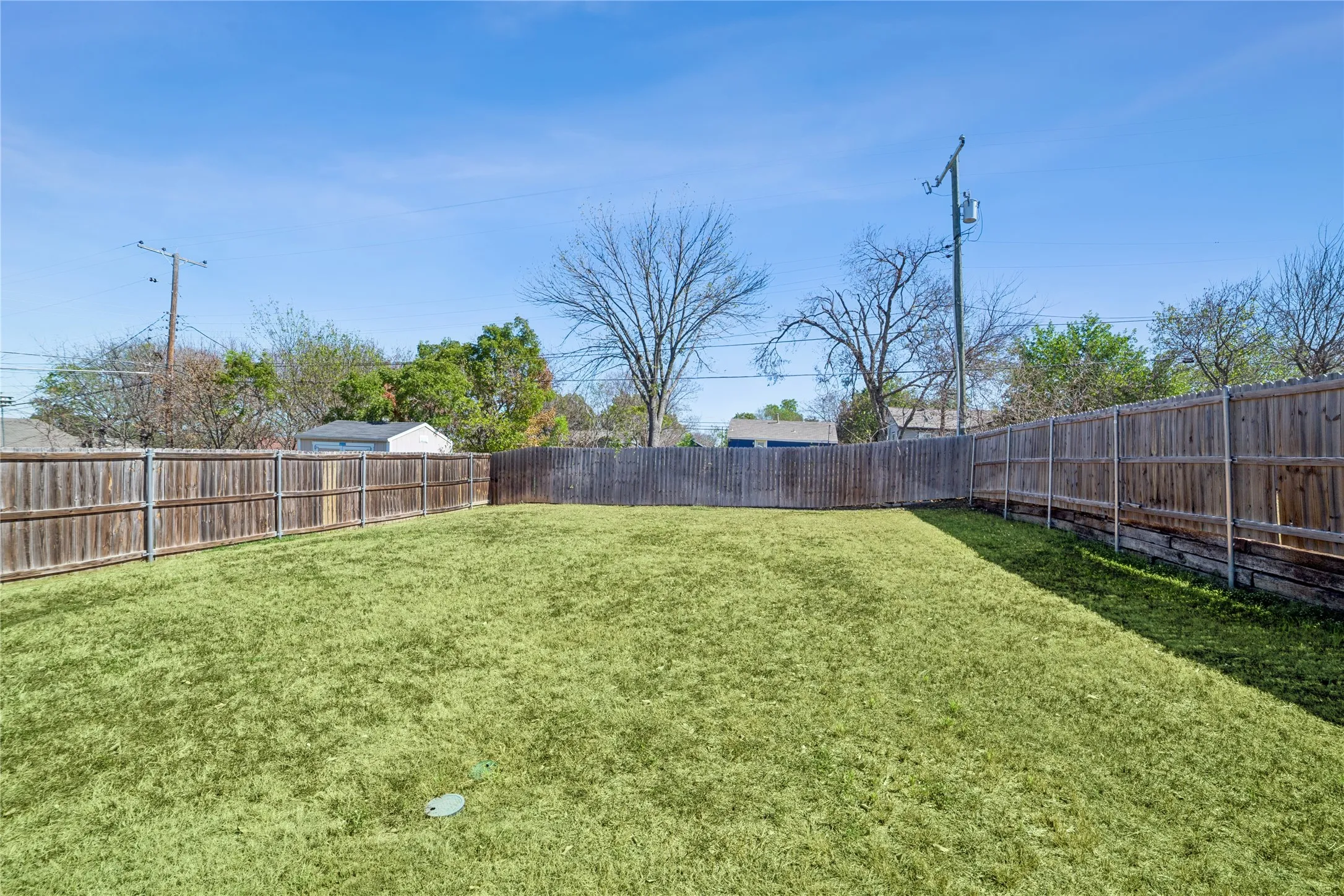 Expansive grassy yard with a wood privacy fence