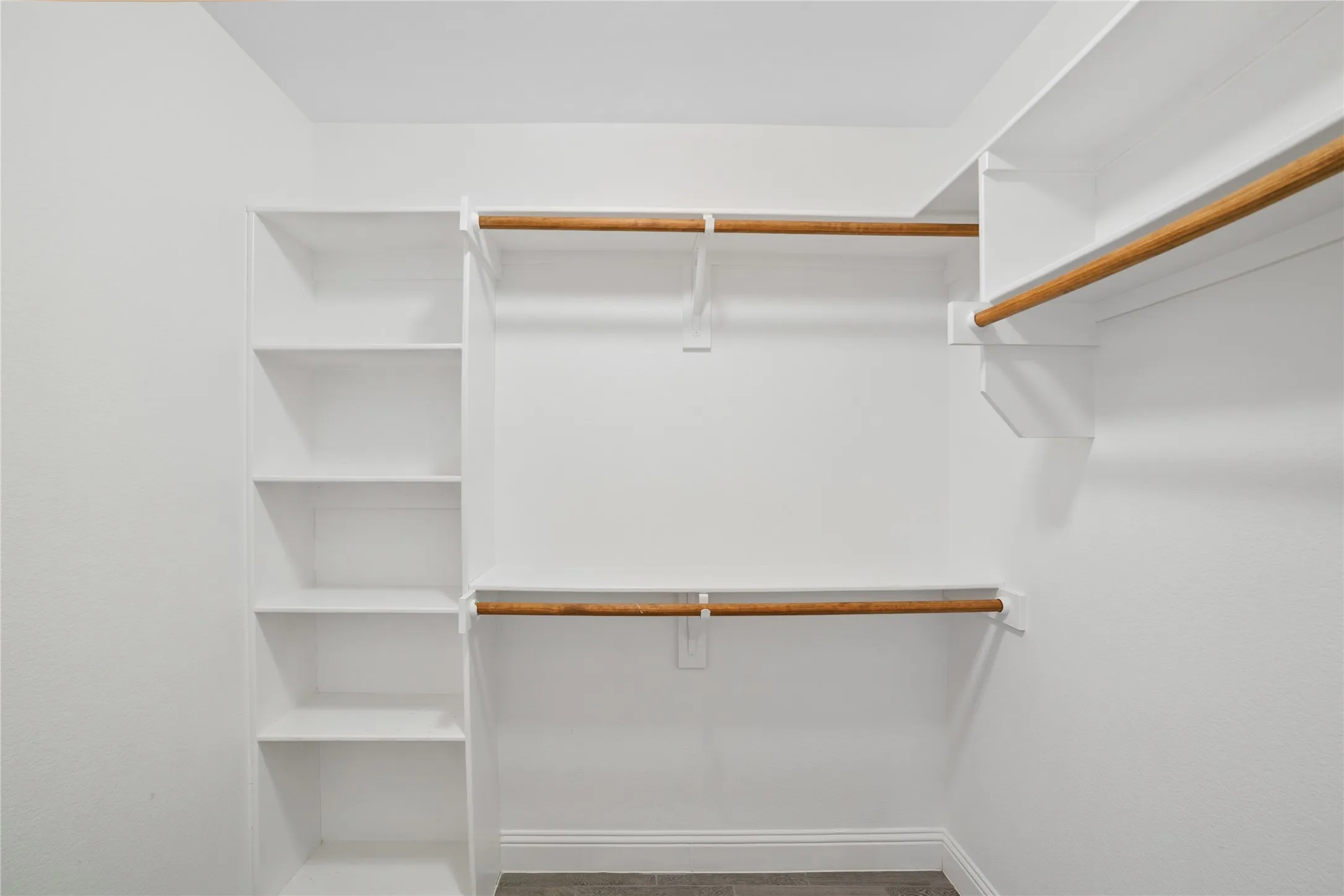 Built-in shelving, multiple hanging rods, durable flooring, and crisp white walls