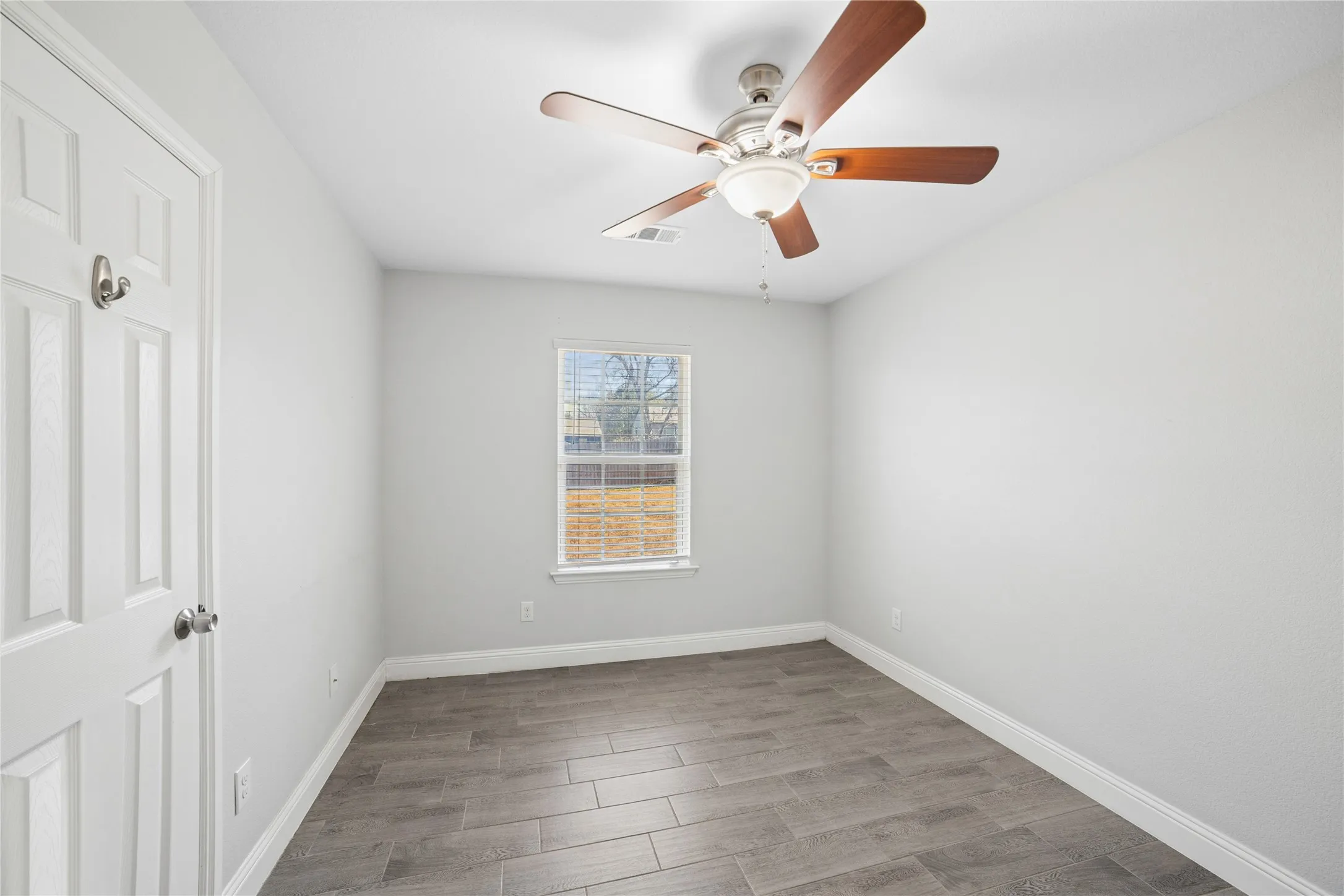 Wood-finish tile flooring complemented by a ceiling fan with light fixture