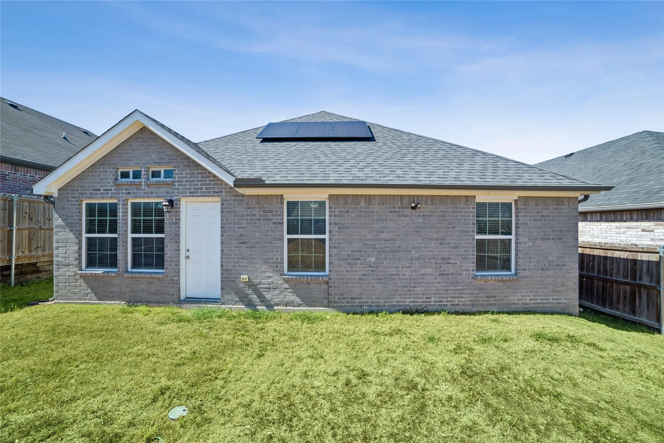 Gray brick exterior with a pitched shingle roof