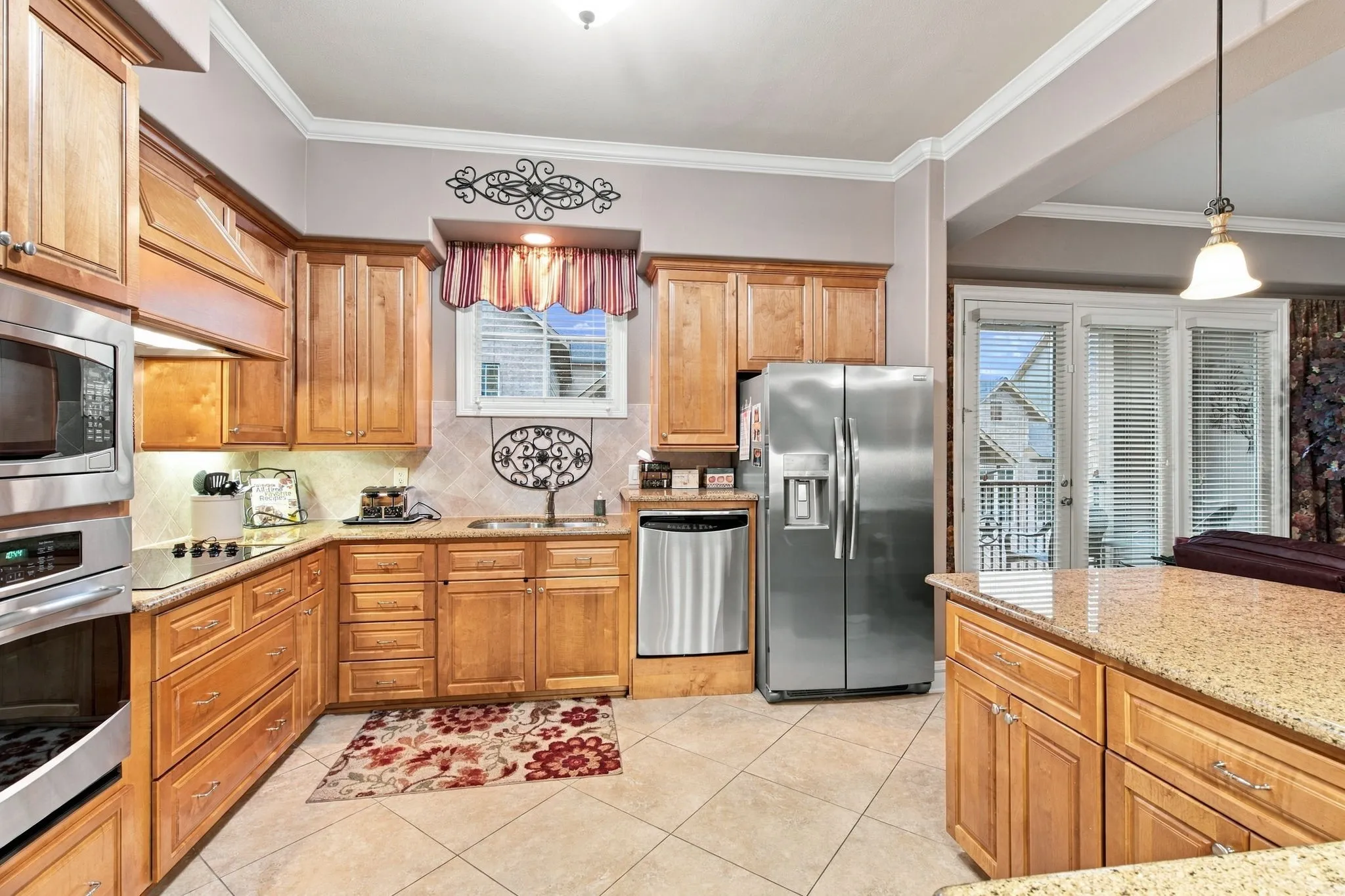 Kitchen featuring wood-finish cabinetry, stainless steel appliances, a tiled backsplash, and light-toned countertops