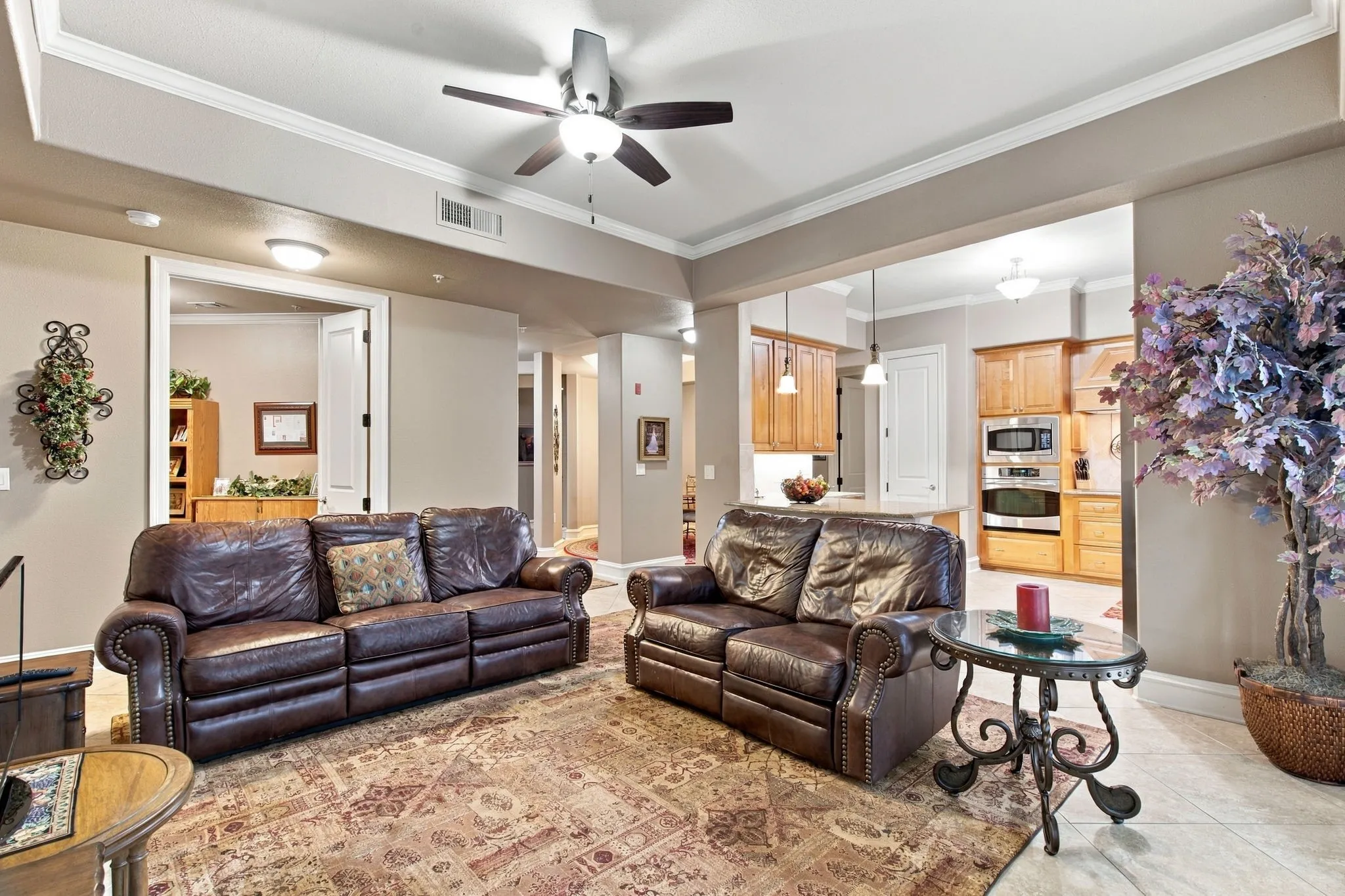 Open living space featuring crown molding, recessed lighting, a ceiling fan, and tile flooring