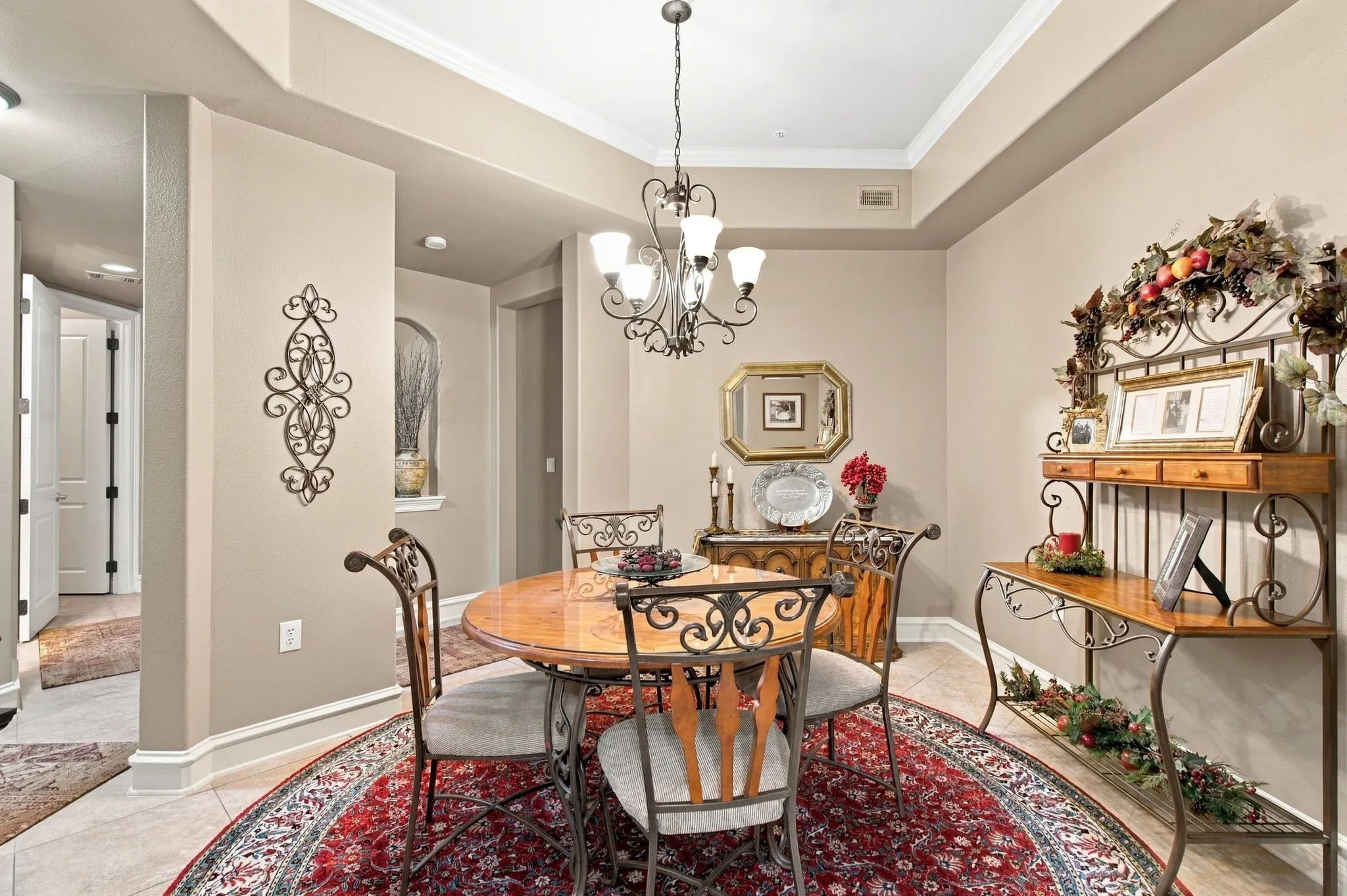Tray ceiling with crown molding, recessed lighting, and a decorative chandelier